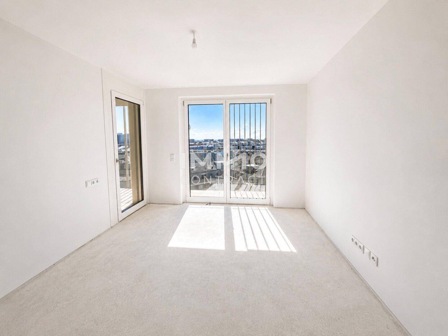 Helles Zimmer mit Zugang zum Balkon und Blick auf die Stadt, ideal als Schlafzimmer.