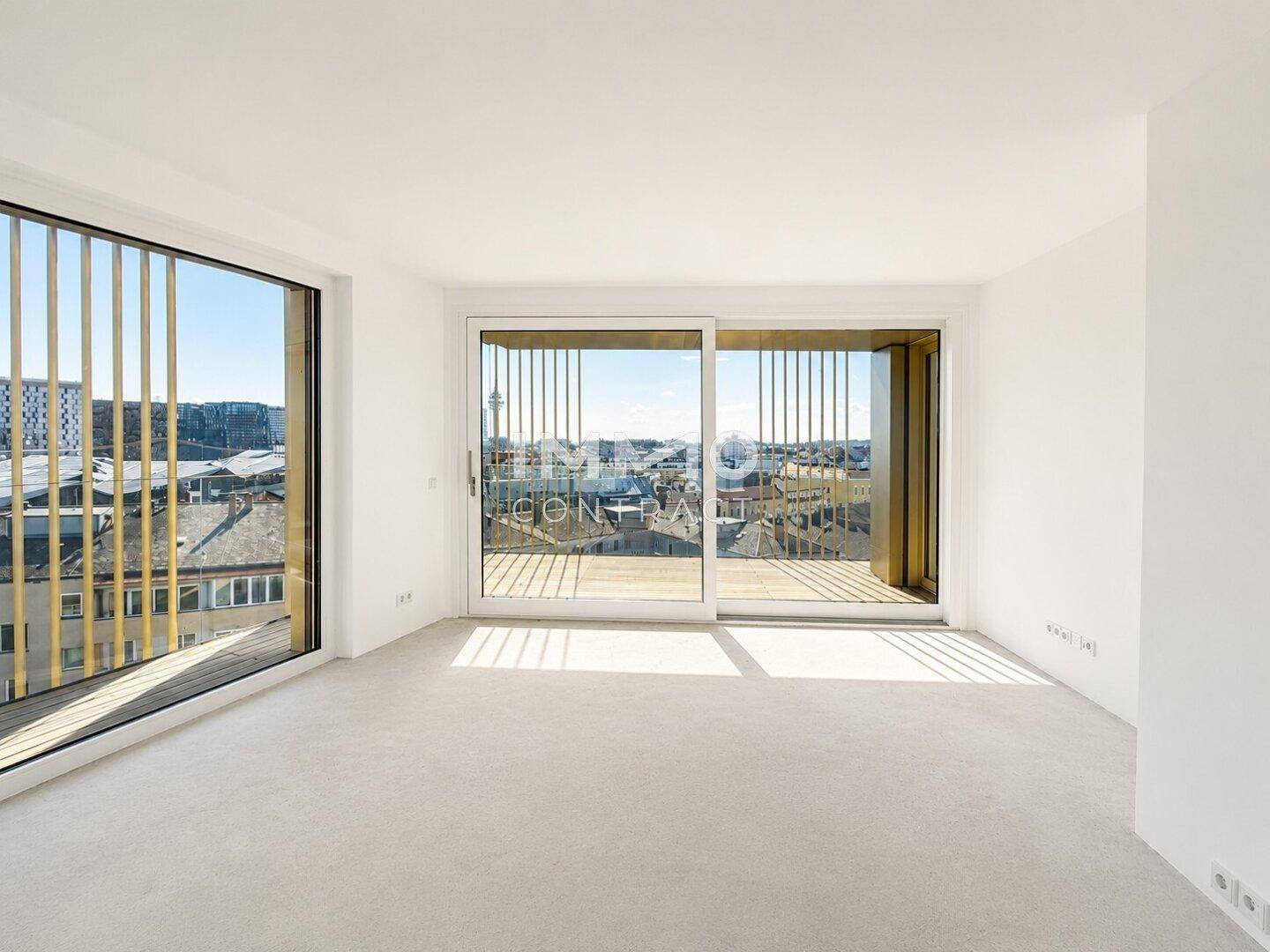Heller Raum mit Schiebetüren zu einem Außenbereich und weitem Blick über die Stadt.