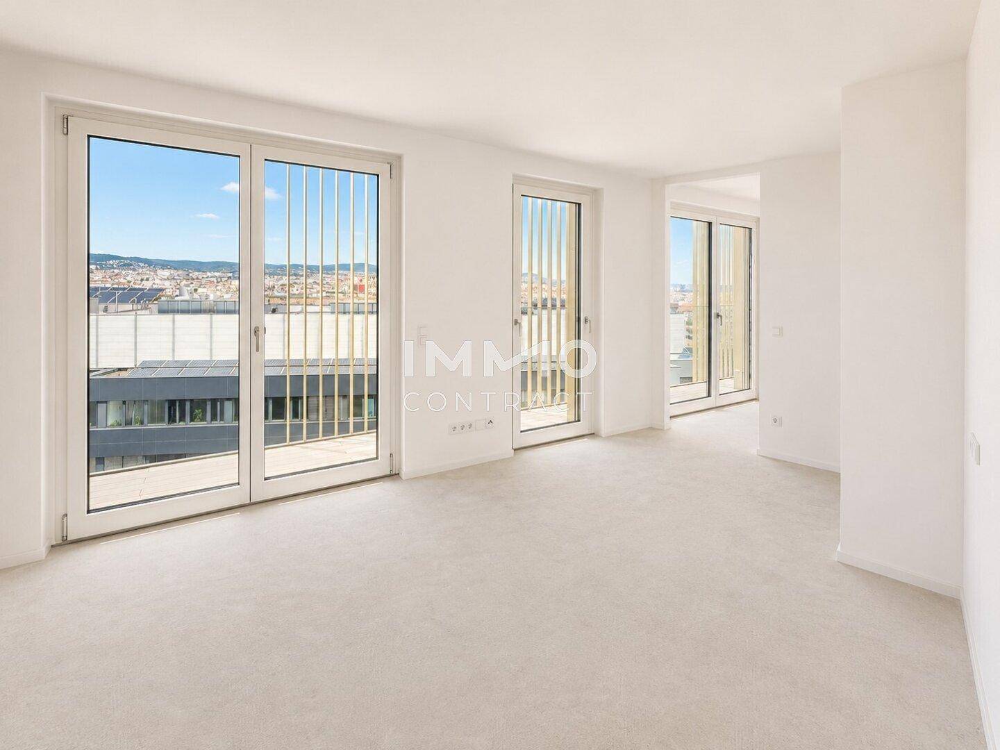 Lichtdurchfluteter Raum mit Teppichboden und Panoramafenstern, die einen weiten Stadtblick bieten.