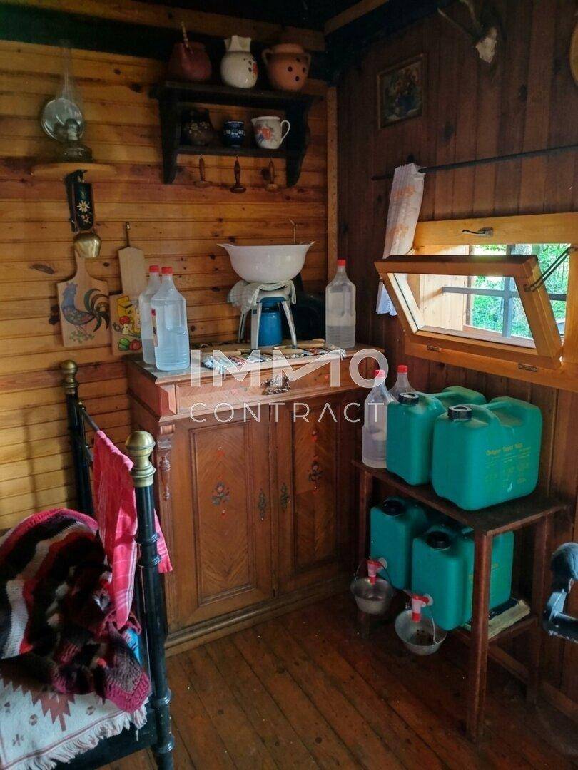Ecke des rustikalen Zimmers mit Holzschrank, Fenster und traditionellen Utensilien.