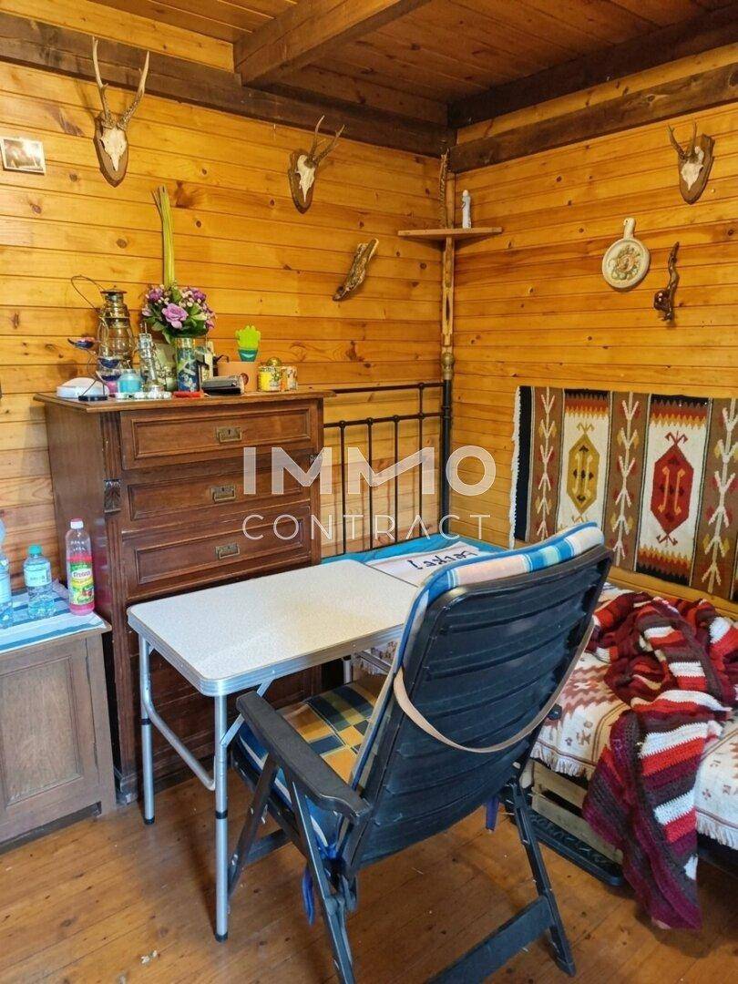 Gemütlicher Innenraum mit Holzwänden, einem Bett und einem Klapptisch.