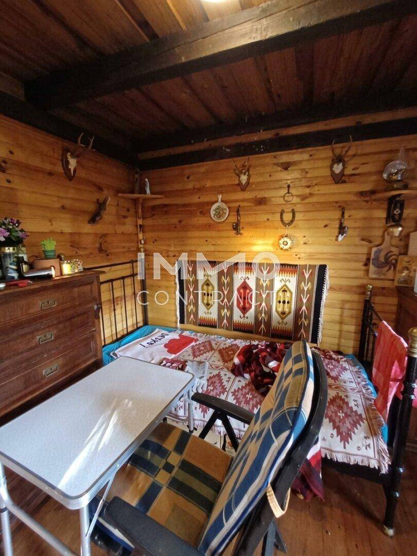 Rustikales Schlafzimmer mit Holzvertäfelung, Hirschgeweihen und traditioneller Dekoration.