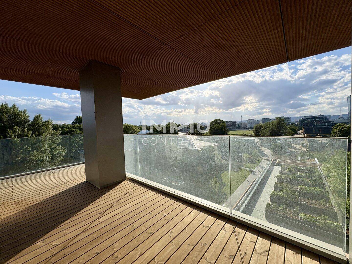Überdachte Terrasse mit Holzboden und Glasgeländer, ideal für entspannte Stunden im Freien.