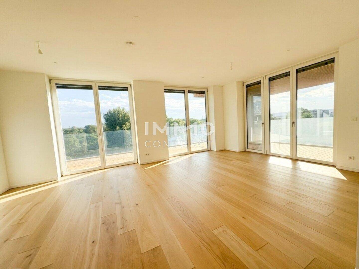 Helles Wohnzimmer mit Eichenparkett und bodentiefen Fenstern, die viel Licht hereinlassen.