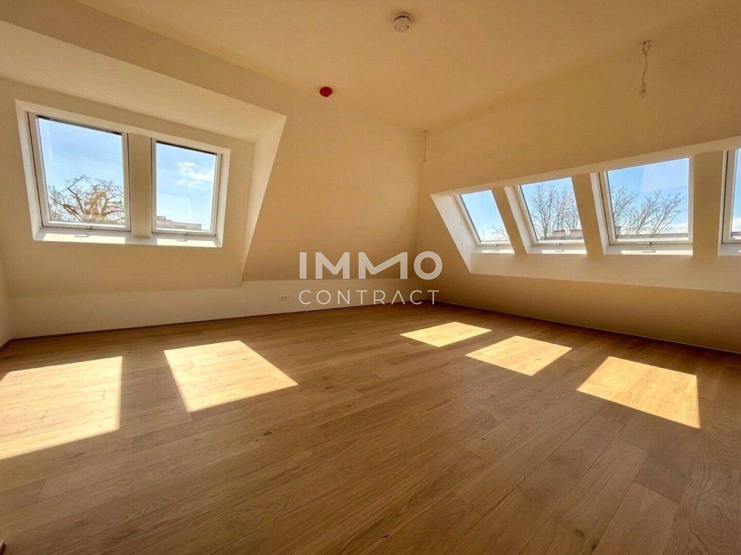 Geräumiges Dachgeschosszimmer mit viel Tageslicht durch die großen Dachfenster und hellem Holzboden.