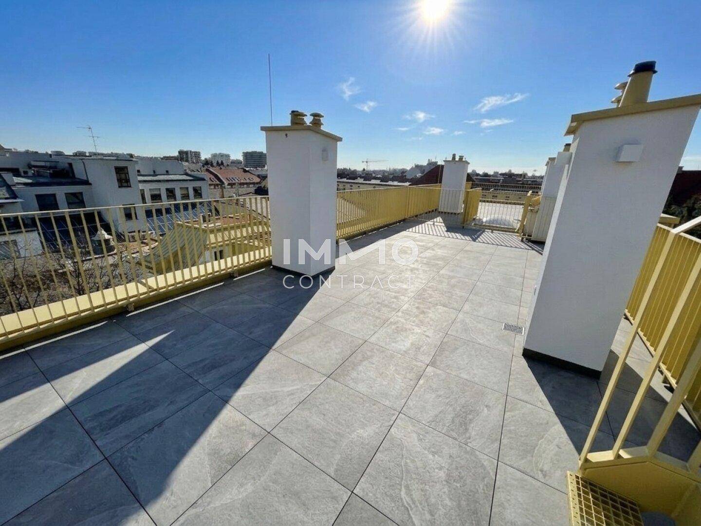 Sonnige Dachterrasse mit weitem Blick über die Dächer der Stadt und modernen Fliesen, ideal zum Entspannen.