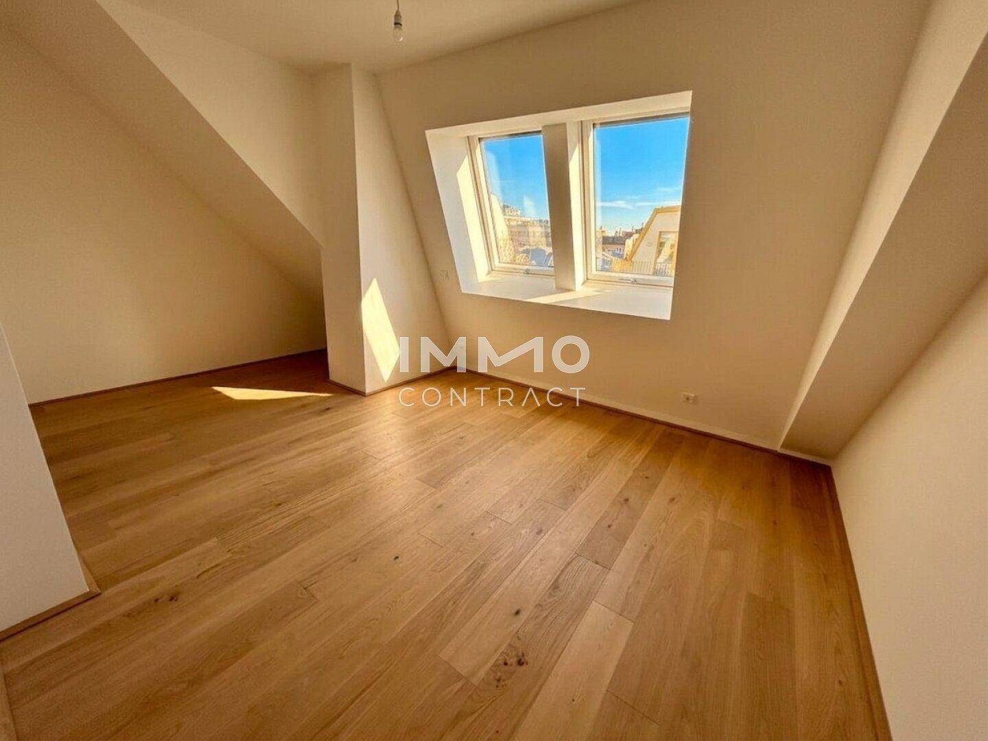 Heller Raum im Dachgeschoss mit Holzboden und schrägen Wänden, ideal für Schlaf- oder Arbeitszimmer.