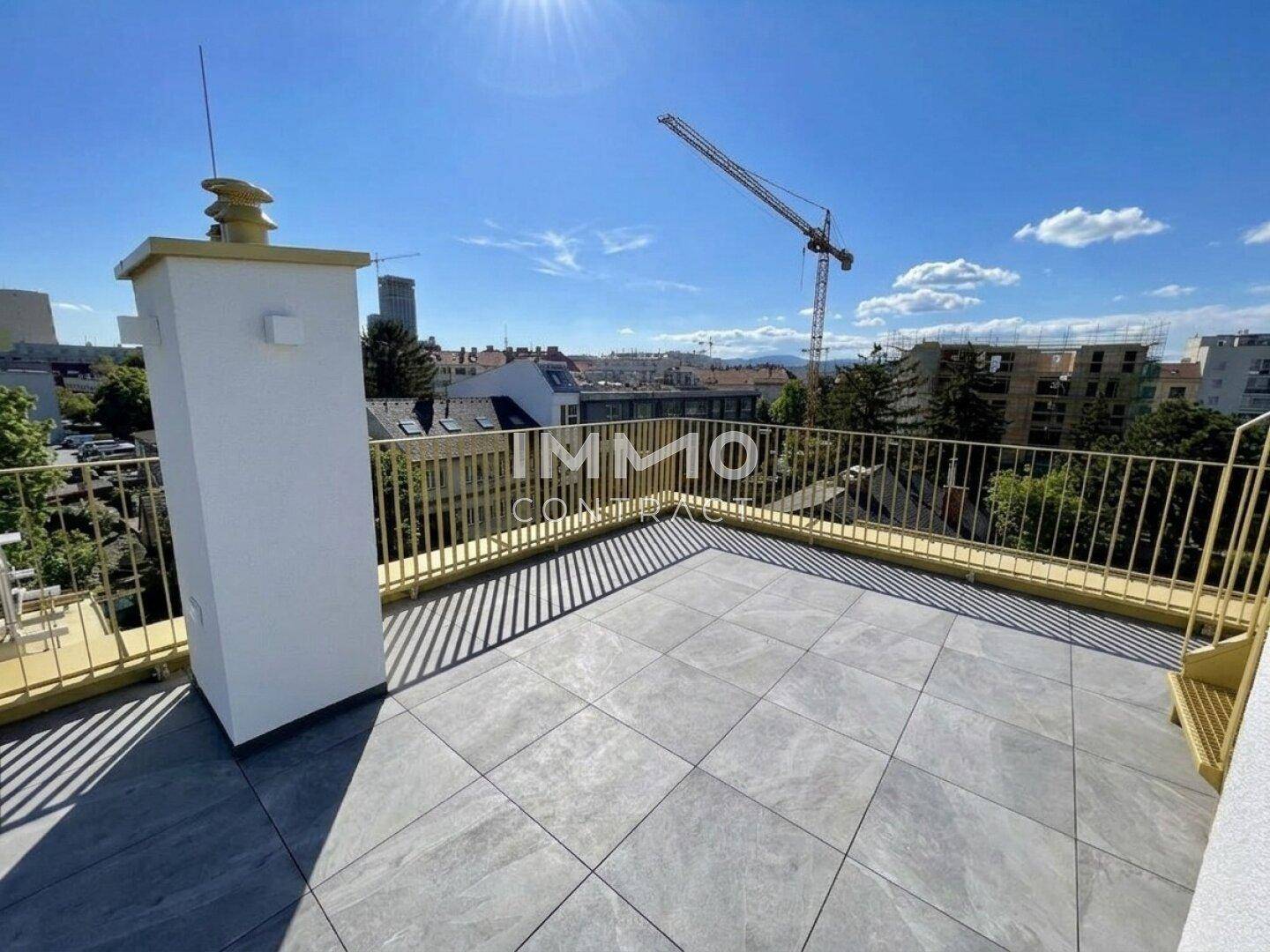 Große Dachterrasse mit Fliesen und gelbem Geländer, ideal für Entspannung im Freien.
