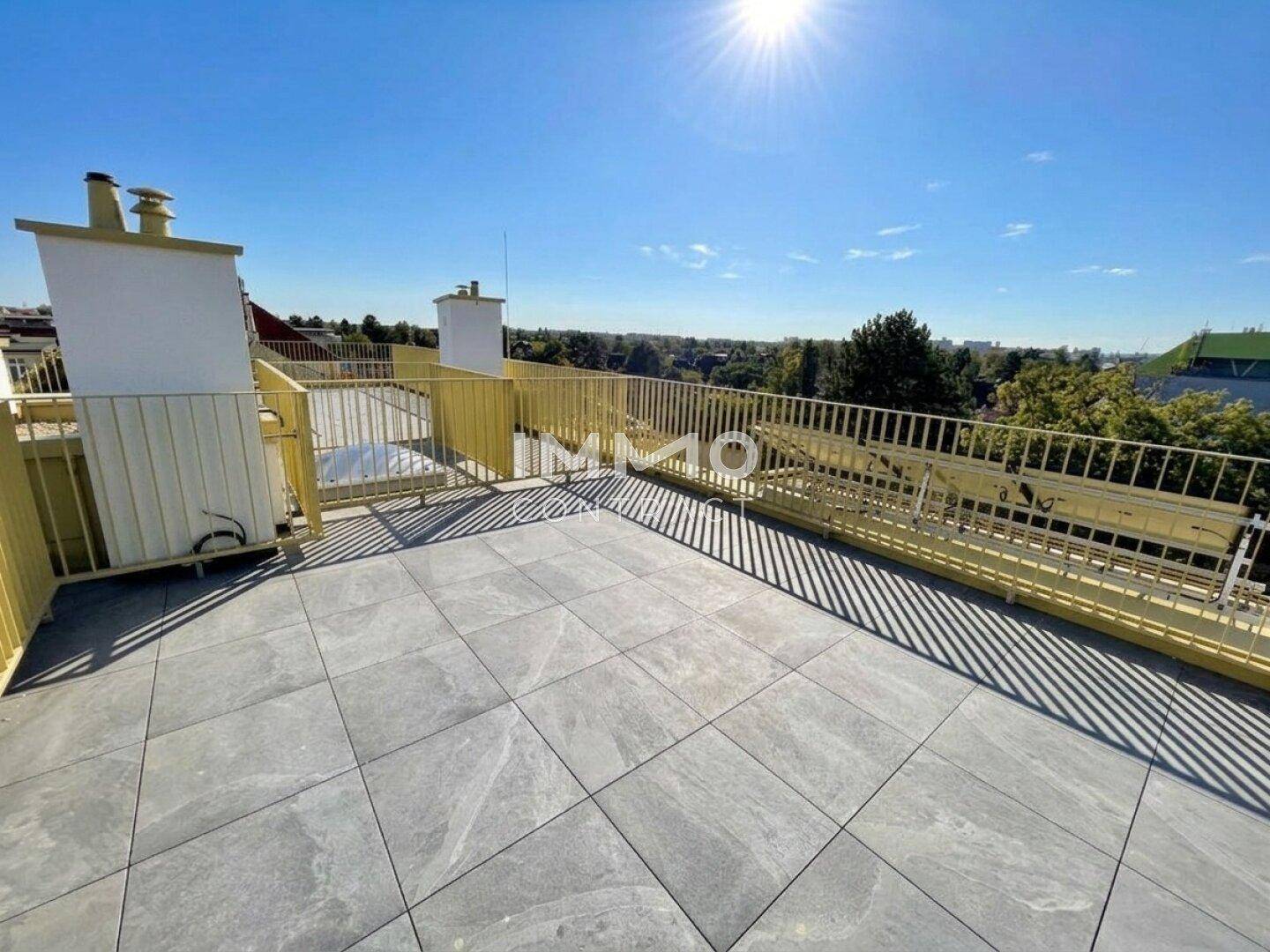 Weitläufige Dachterrasse mit modernem Fliesenboden und sonnigem Ausblick.