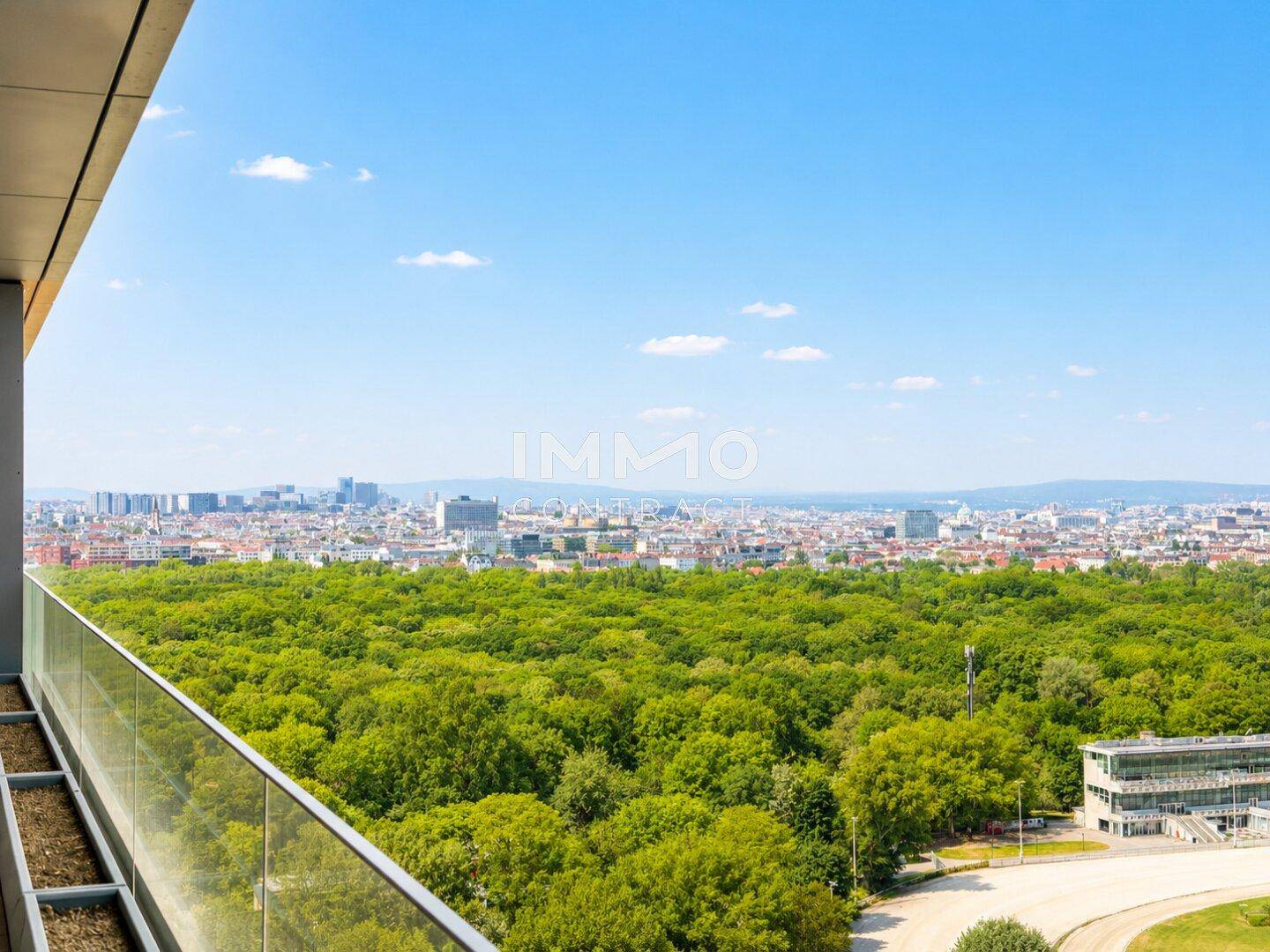 Panoramablick über eine weitläufige Grünfläche und die Stadt, aufgenommen von einem hohen Gebäude.