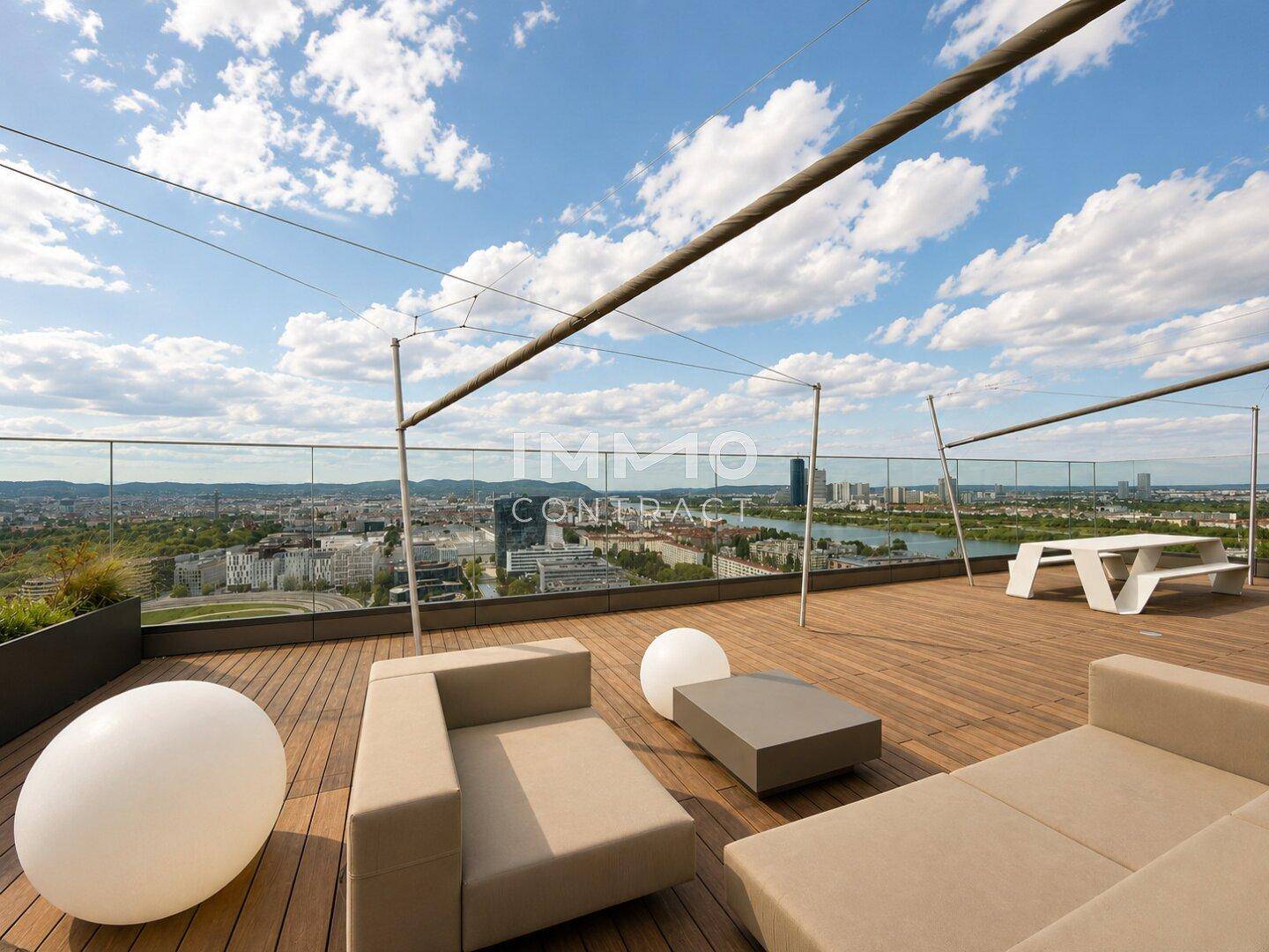 Geräumige Dachterrasse mit Lounge-Möbeln und Esstisch, bietet einen weiten Blick über die Stadt.