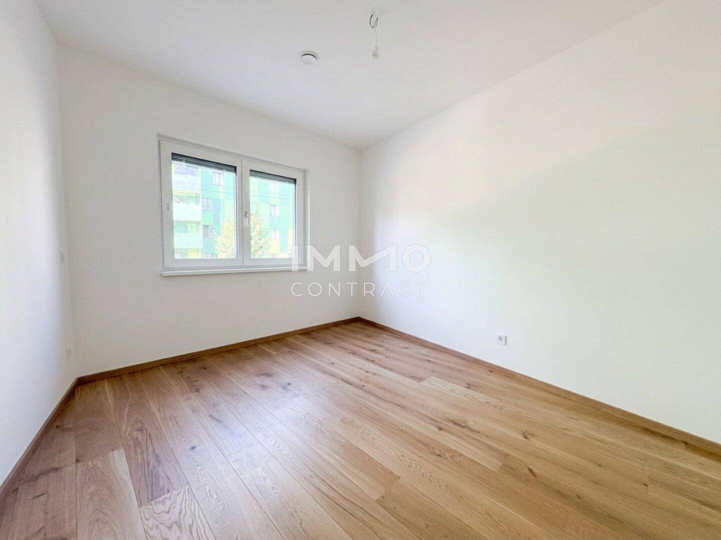 Leeres Zimmer mit hellem Holzboden und Fenster, bietet viel Licht und Raum für neue Ideen.