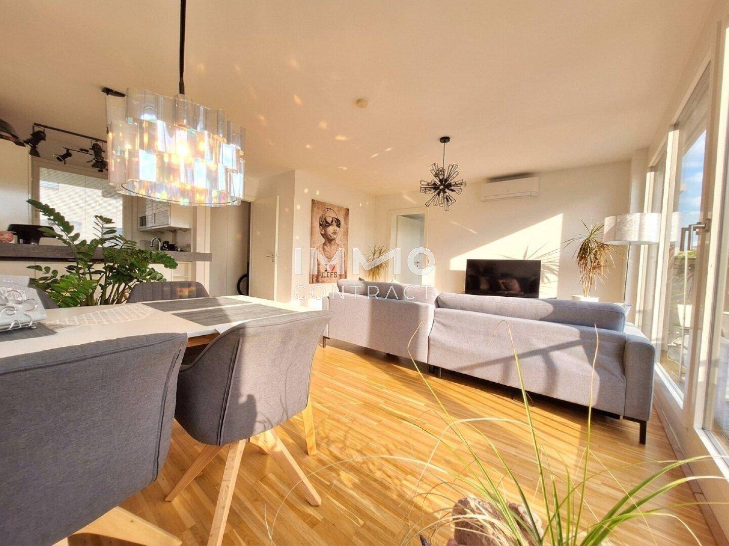 Helles Wohn- und Esszimmer mit Holzboden, modernen Möbeln und Zugang zur Terrasse.
