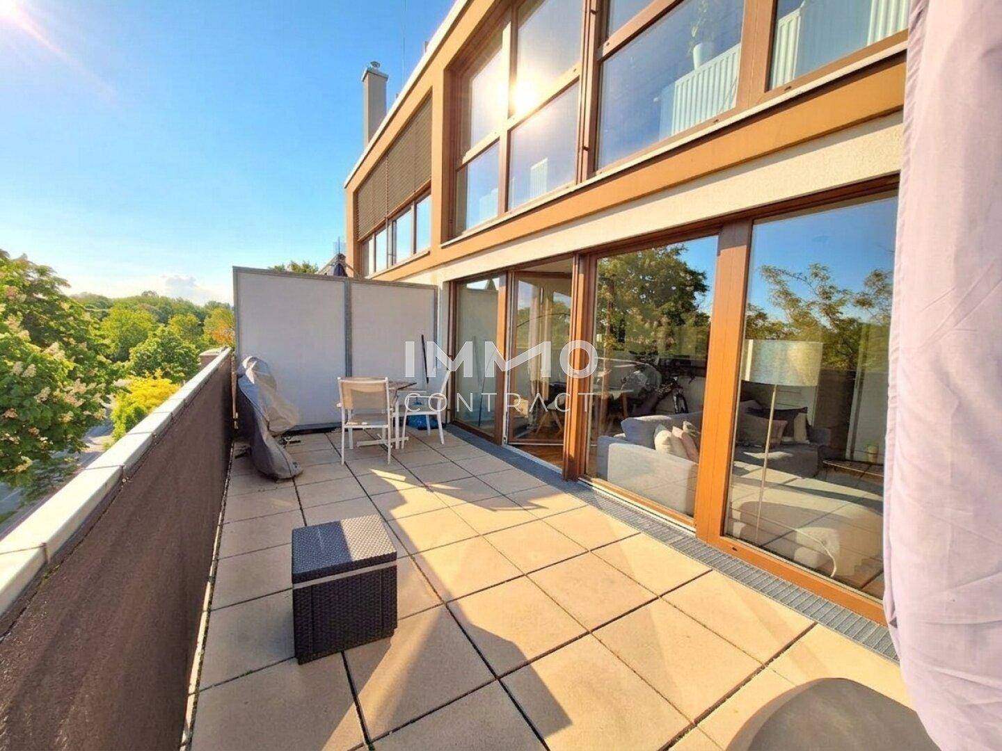 Große Sonnenterrasse mit Fliesenboden und Blick auf die Umgebung, zugänglich vom Wohnbereich.