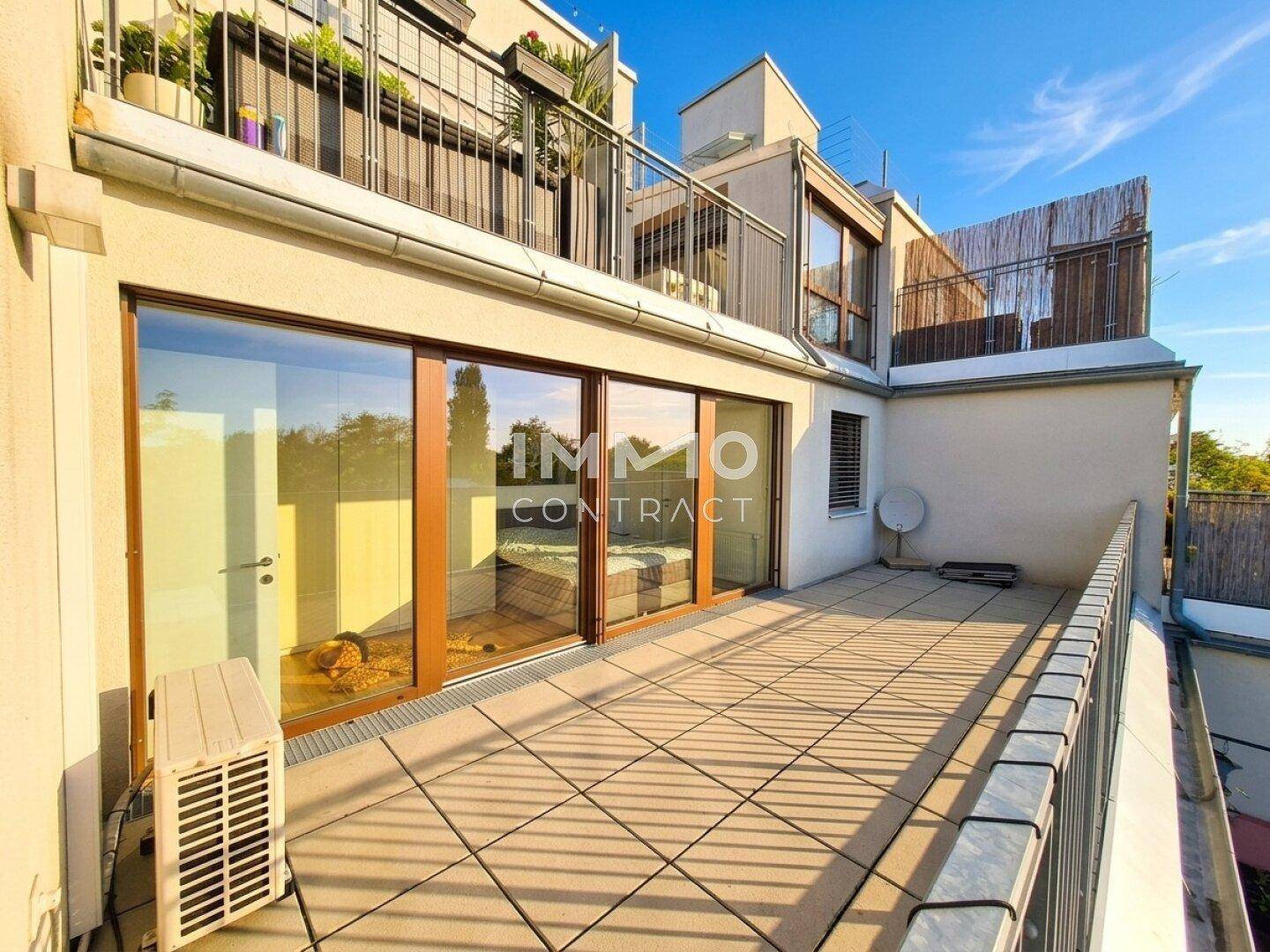 Große Dachterrasse mit Fliesenboden und Blick auf die umliegenden Gebäude.