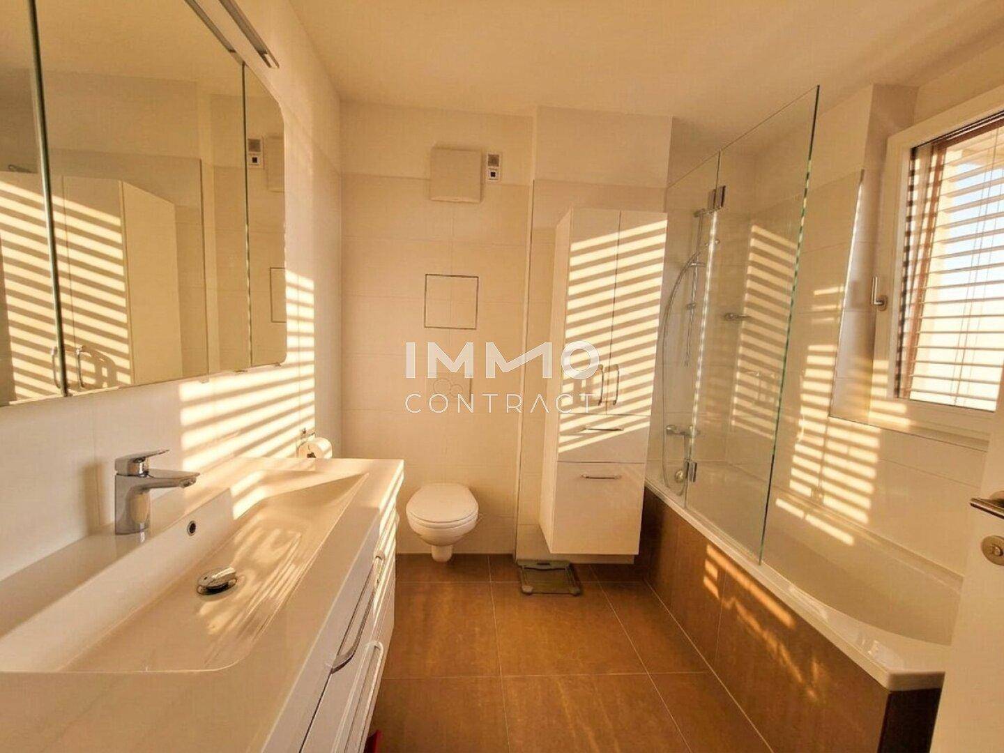 Modernes Badezimmer mit Badewanne, Dusche, Einzelwaschbecken und Fenster.