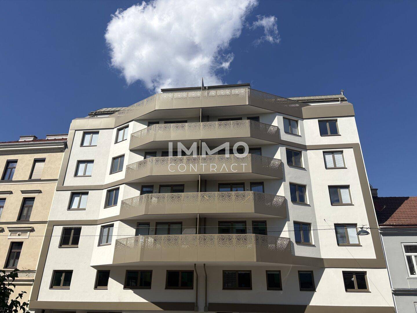 Ansicht eines modernen Wohngebäudes mit mehreren Balkonen und einer hellen Fassade.