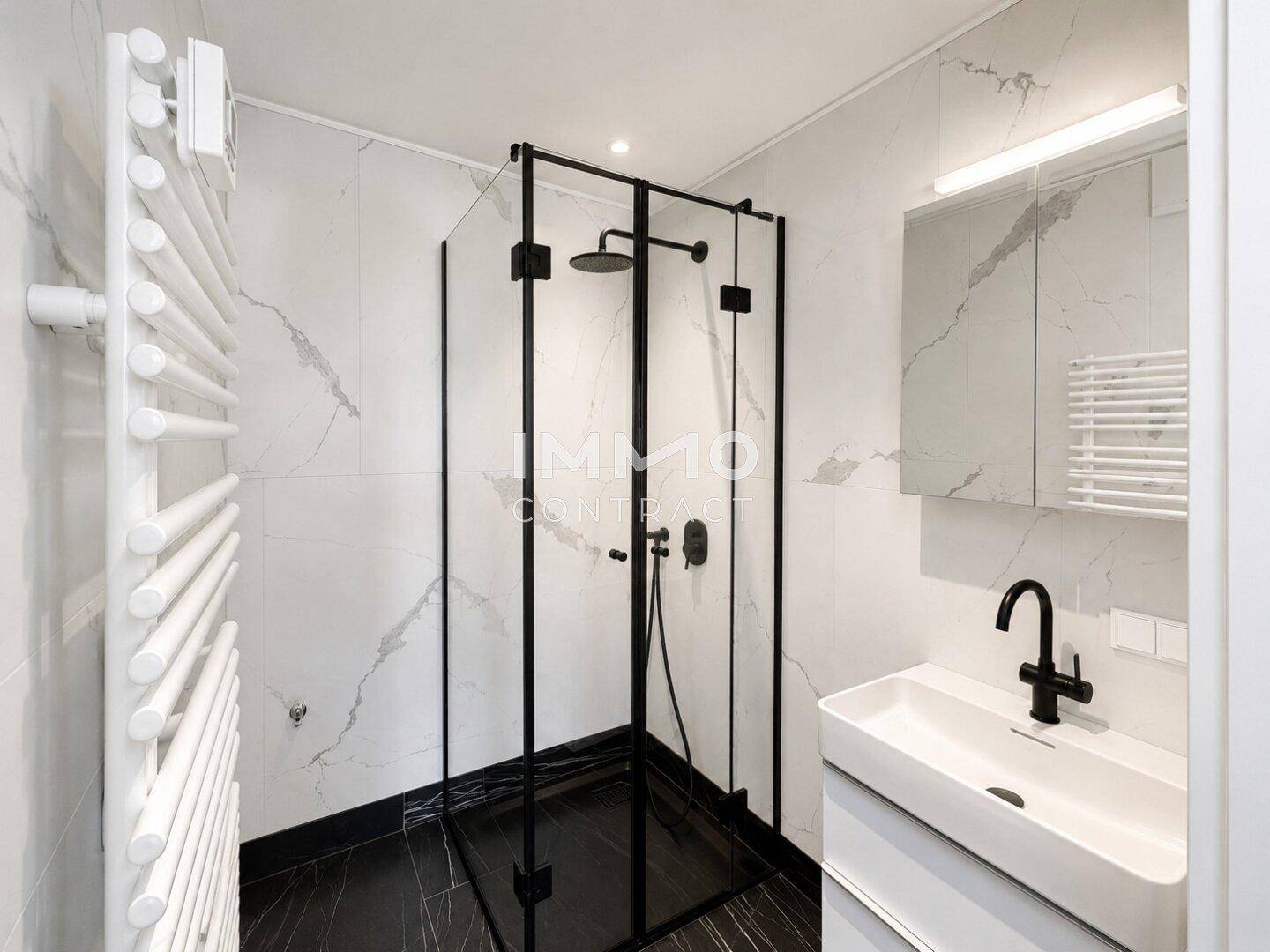 Modernes Badezimmer mit begehbarer Dusche, Marmoroptik-Fliesen und beheiztem Handtuchhalter.