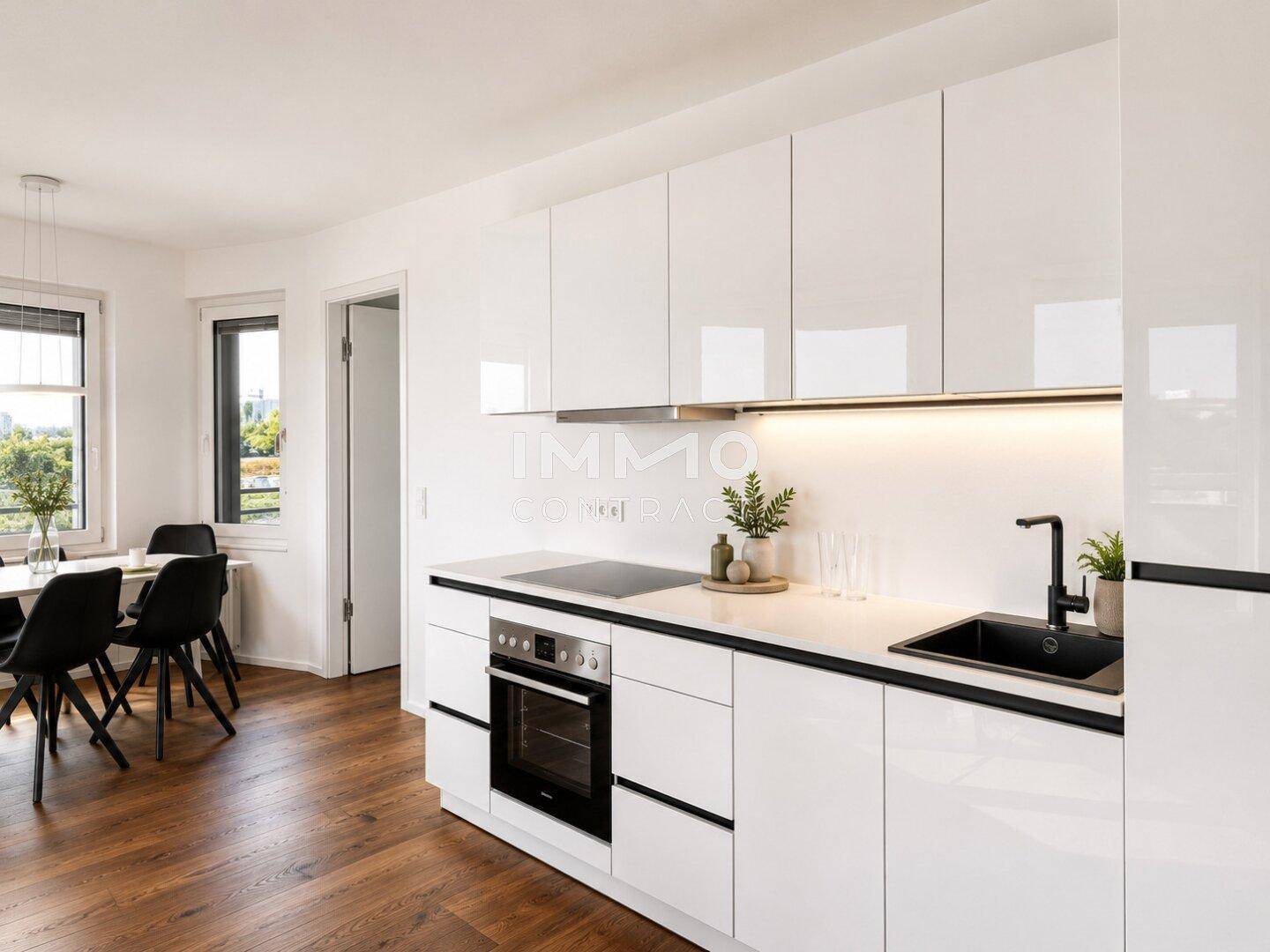 Elegante moderne Küche mit weißen Hochglanzfronten, integrierten Geräten und Essbereich.