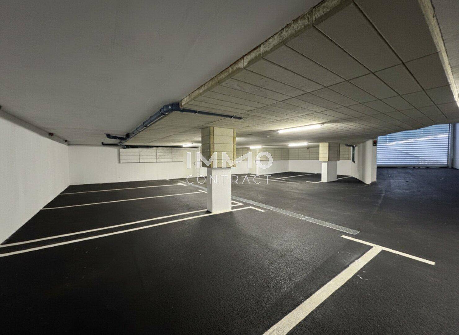 Geräumige Tiefgarage mit markierten Parkplätzen und Betonboden.