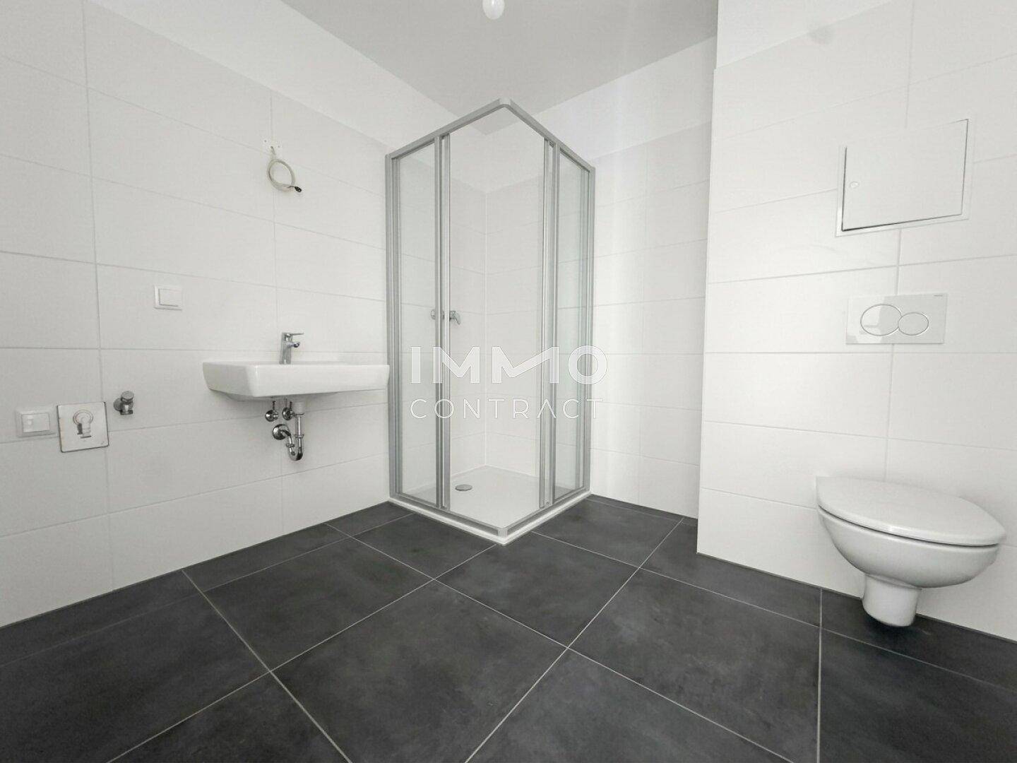 Modernes Badezimmer mit Duschkabine, Waschbecken und wandhängendem WC.