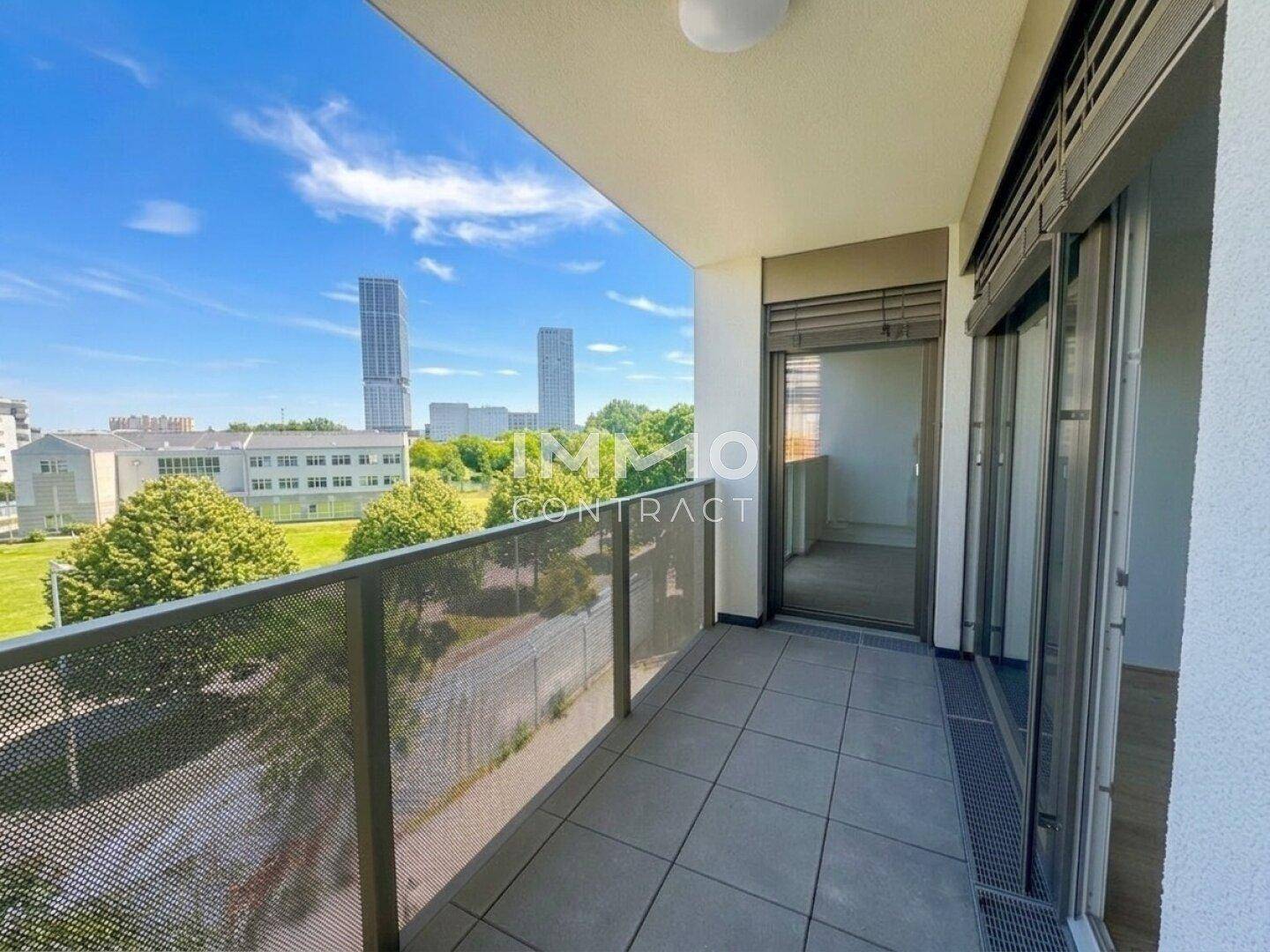 Langer Balkon mit Fliesenboden und Metallgeländer, bietet einen weiten Blick auf die Umgebung.