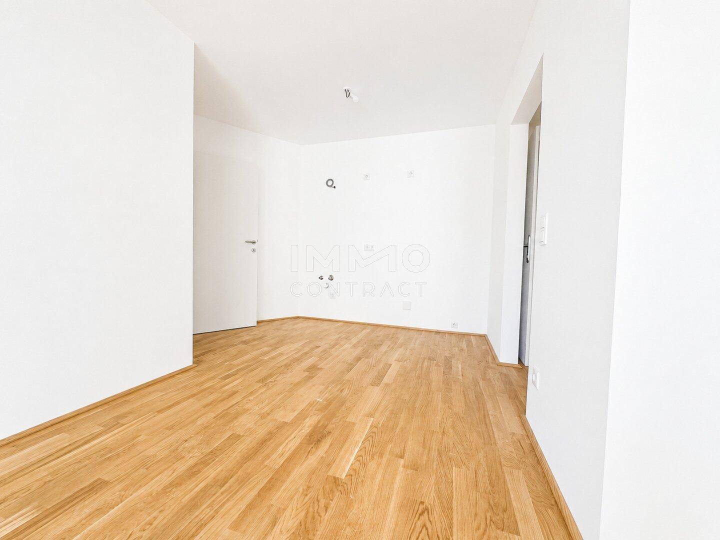 Leerer Raum mit hellem Holzboden und weißen Wänden, ideal für verschiedene Nutzungsmöglichkeiten.