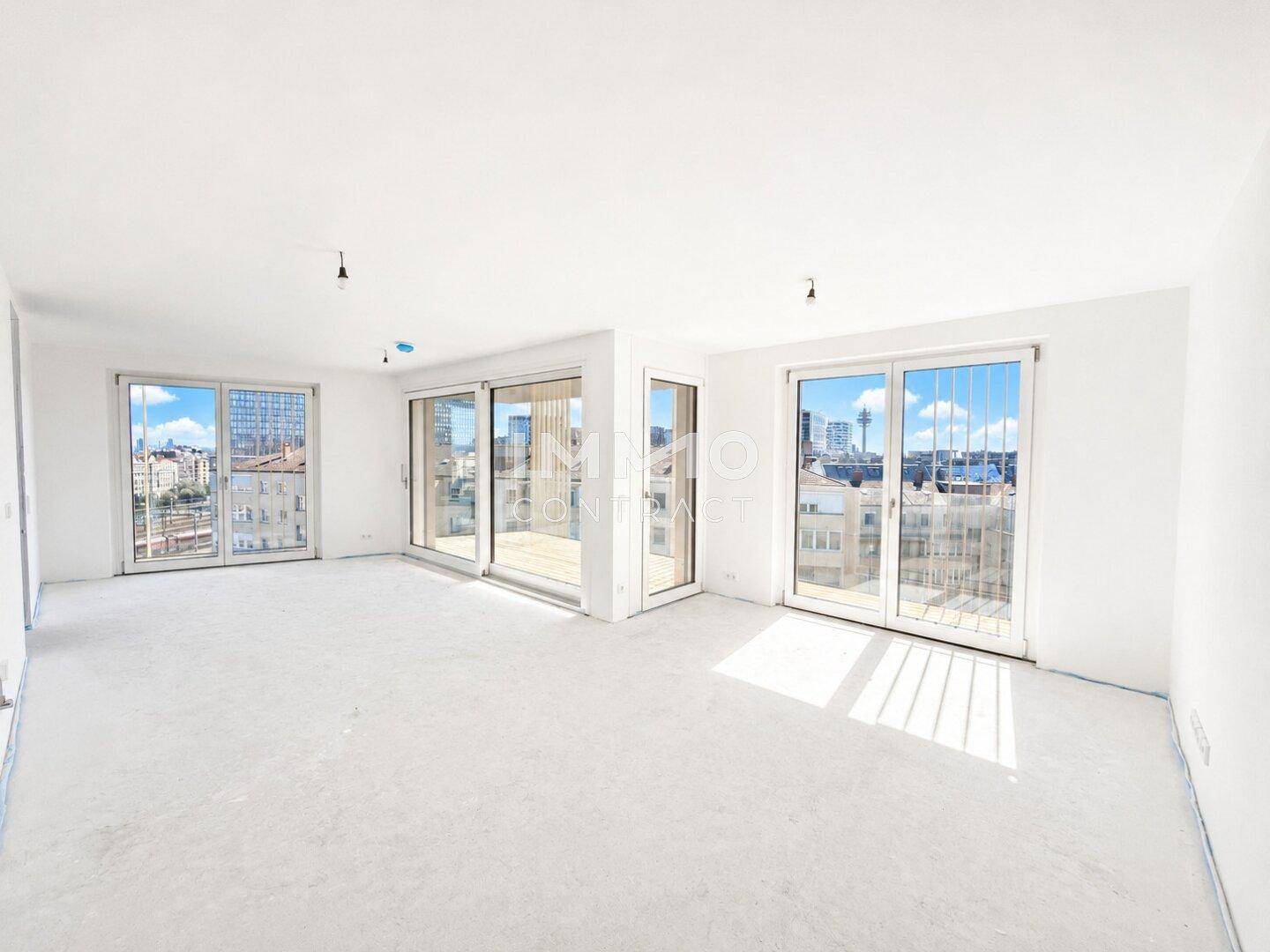 Geräumiger Wohnbereich mit viel Tageslicht durch große Fenster und einem hellen Teppichboden.