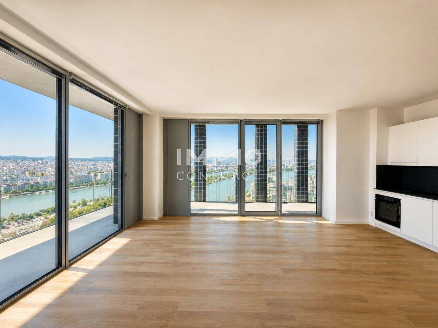 Heller Wohnraum mit großen Panoramafenstern, Holzboden und integrierter Küchenzeile mit Stadtblick.