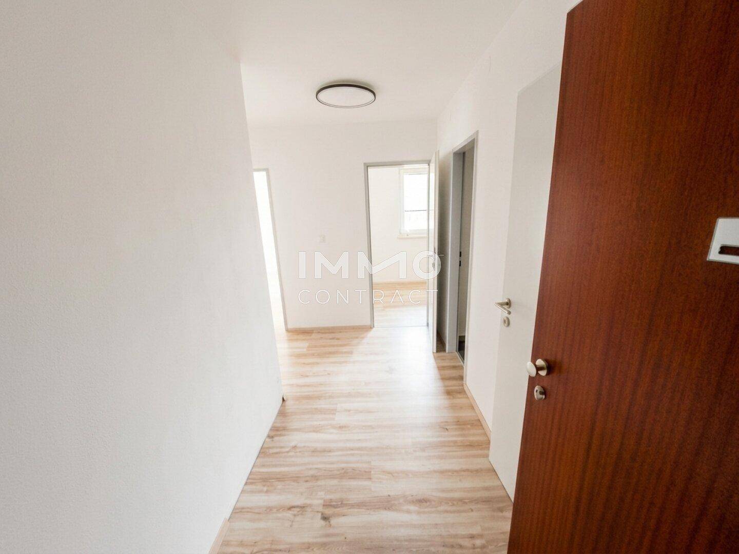 Heller Flur mit Laminatboden und Zugang zu verschiedenen Zimmern der Wohnung.