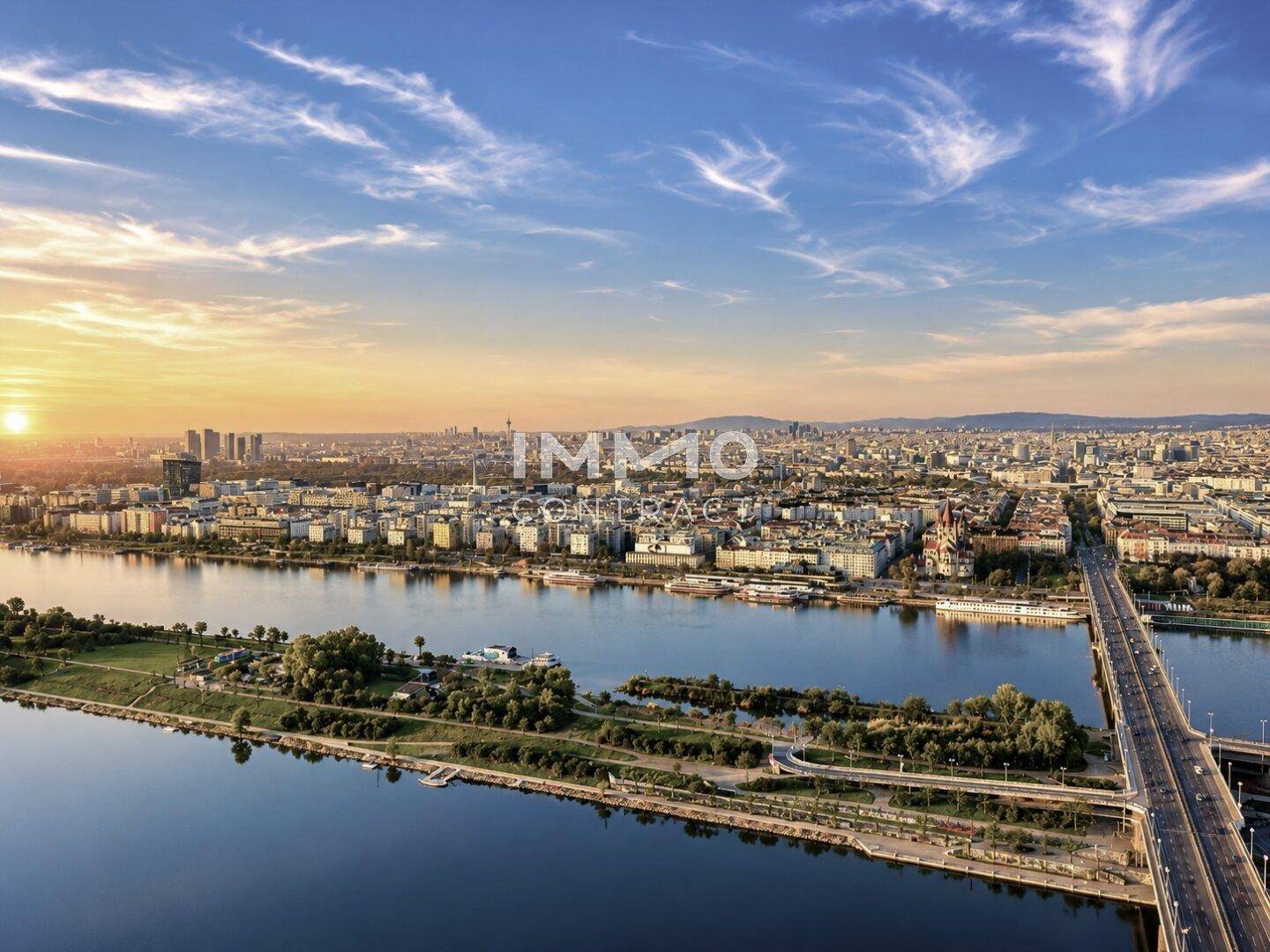 Panoramische Luftaufnahme der Stadt mit Fluss, Brücken und urbaner Bebauung bei Sonnenuntergang.
