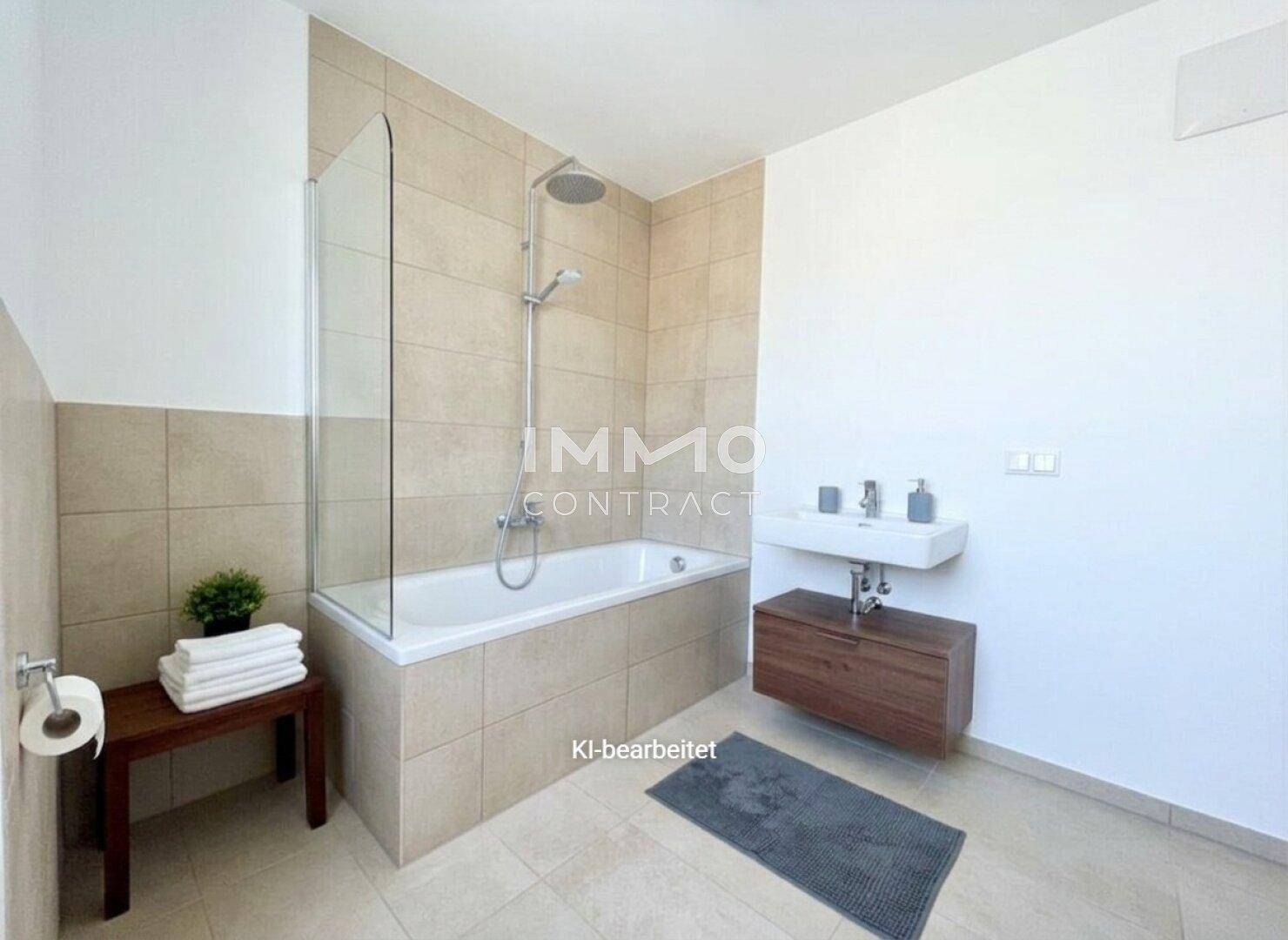 Modernes Badezimmer mit Badewanne, Duschabtrennung, Wandwaschbecken und hellen Fliesen.