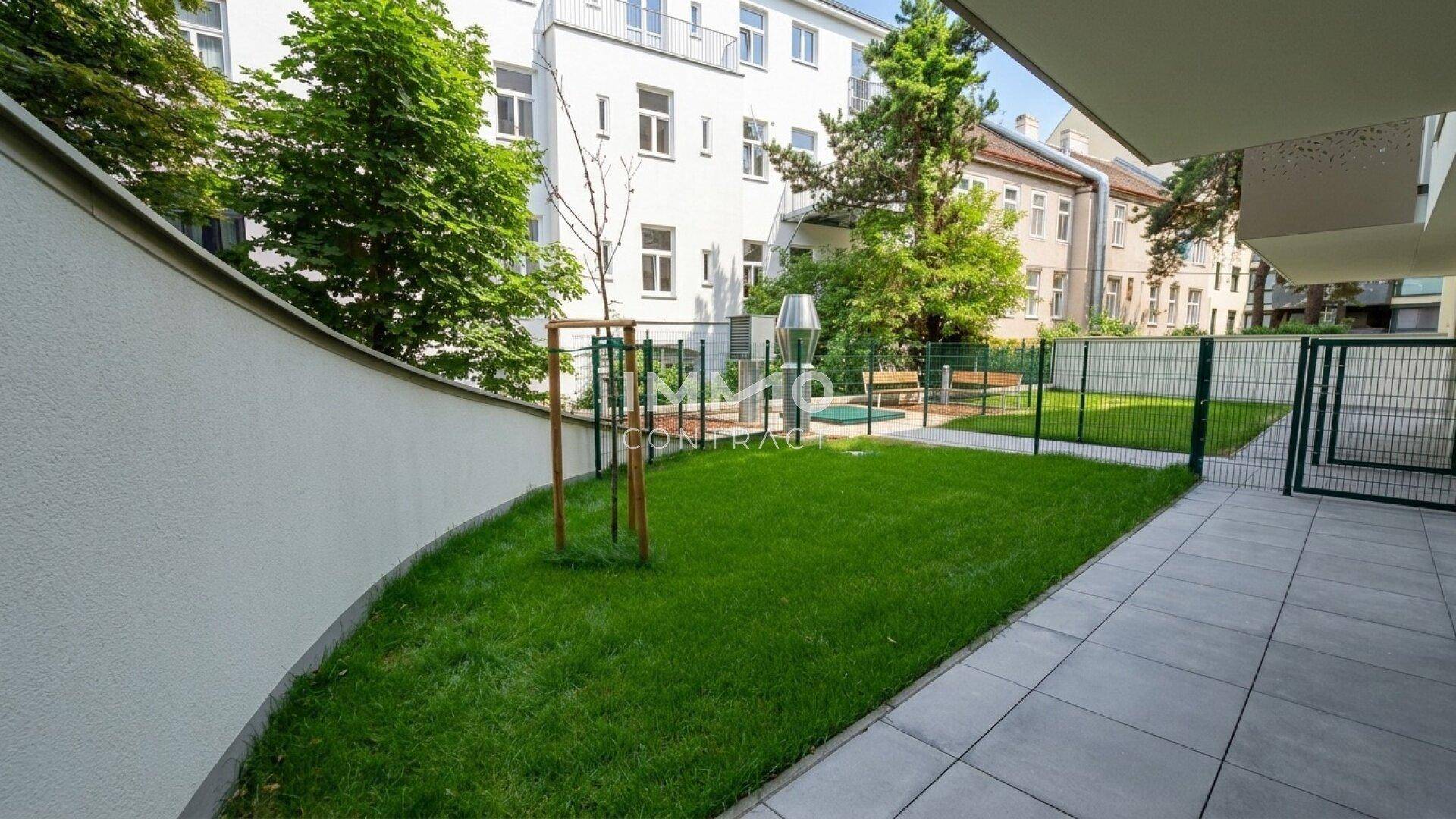 Gepflegter Gemeinschaftsgarten mit Rasenfläche, Sitzbänken und einem kleinen Spielbereich für Kinder.