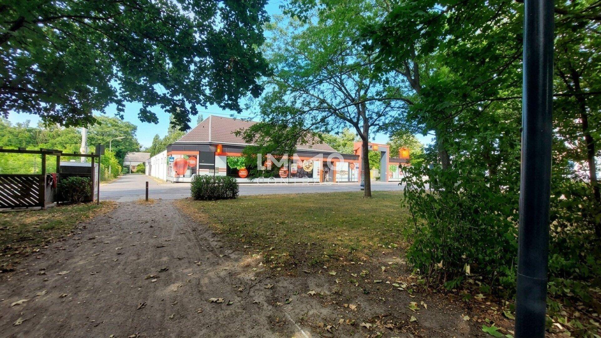 Blick auf ein kommerzielles Gebäude, möglicherweise ein Restaurant, umgeben von Bäumen und Grünflächen.