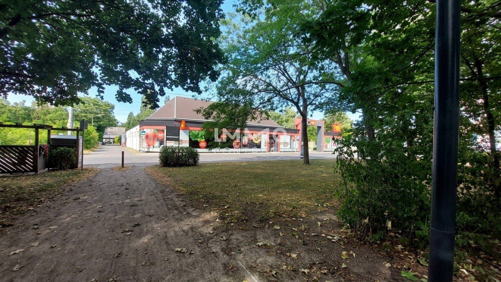 Gebäude umgeben von Bäumen und einem Feldweg, möglicherweise ein Geschäft oder Wohnhaus.
