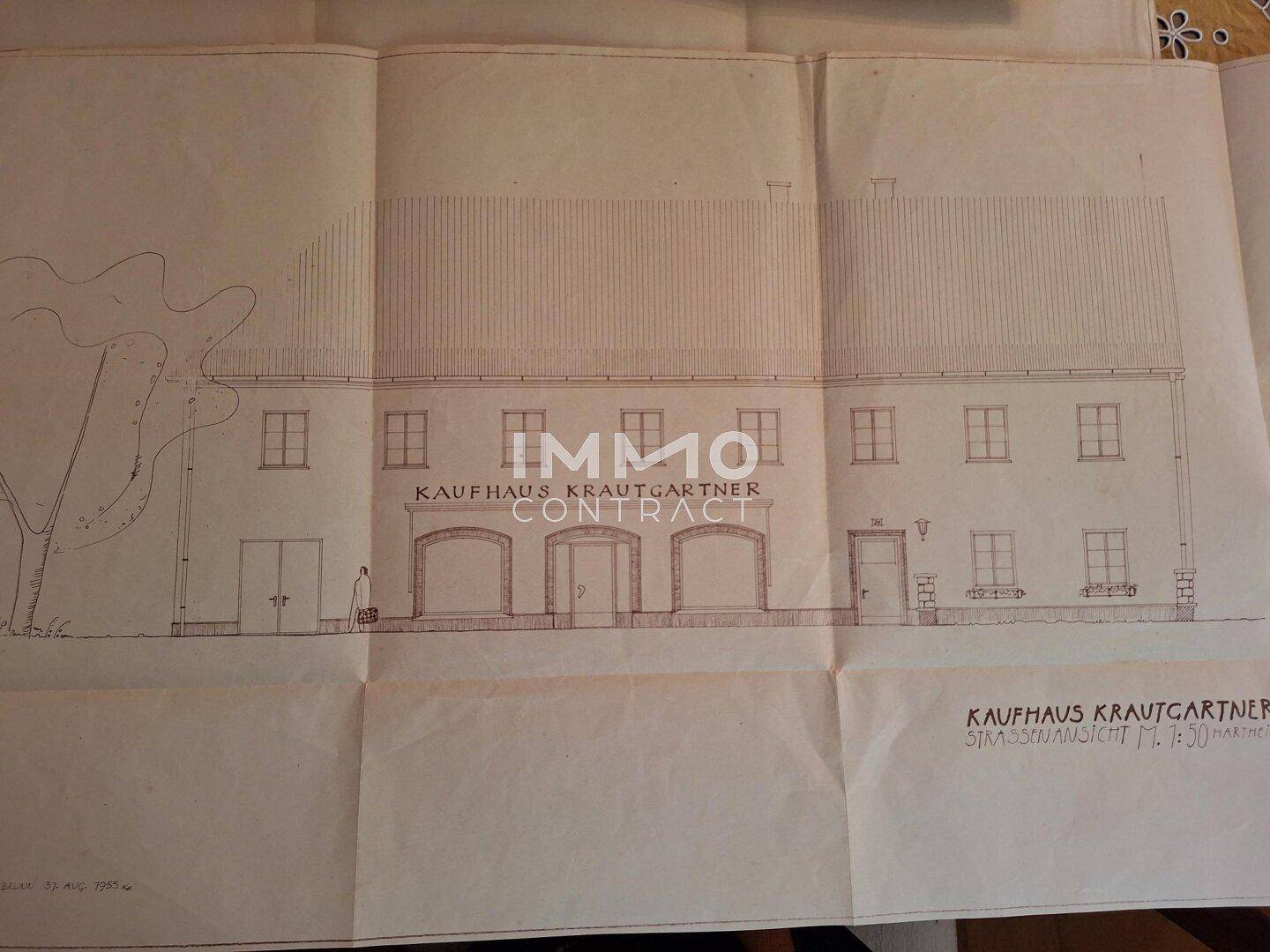 Historischer Aufrissplan eines Kaufhauses mit mehreren Fenstern und Türen, gezeichnet auf Papier.