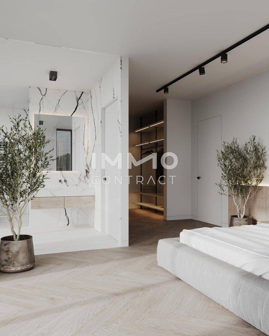 Schlafzimmer mit offenem Zugang zu einem luxuriösen Badezimmer und Ankleidebereich.