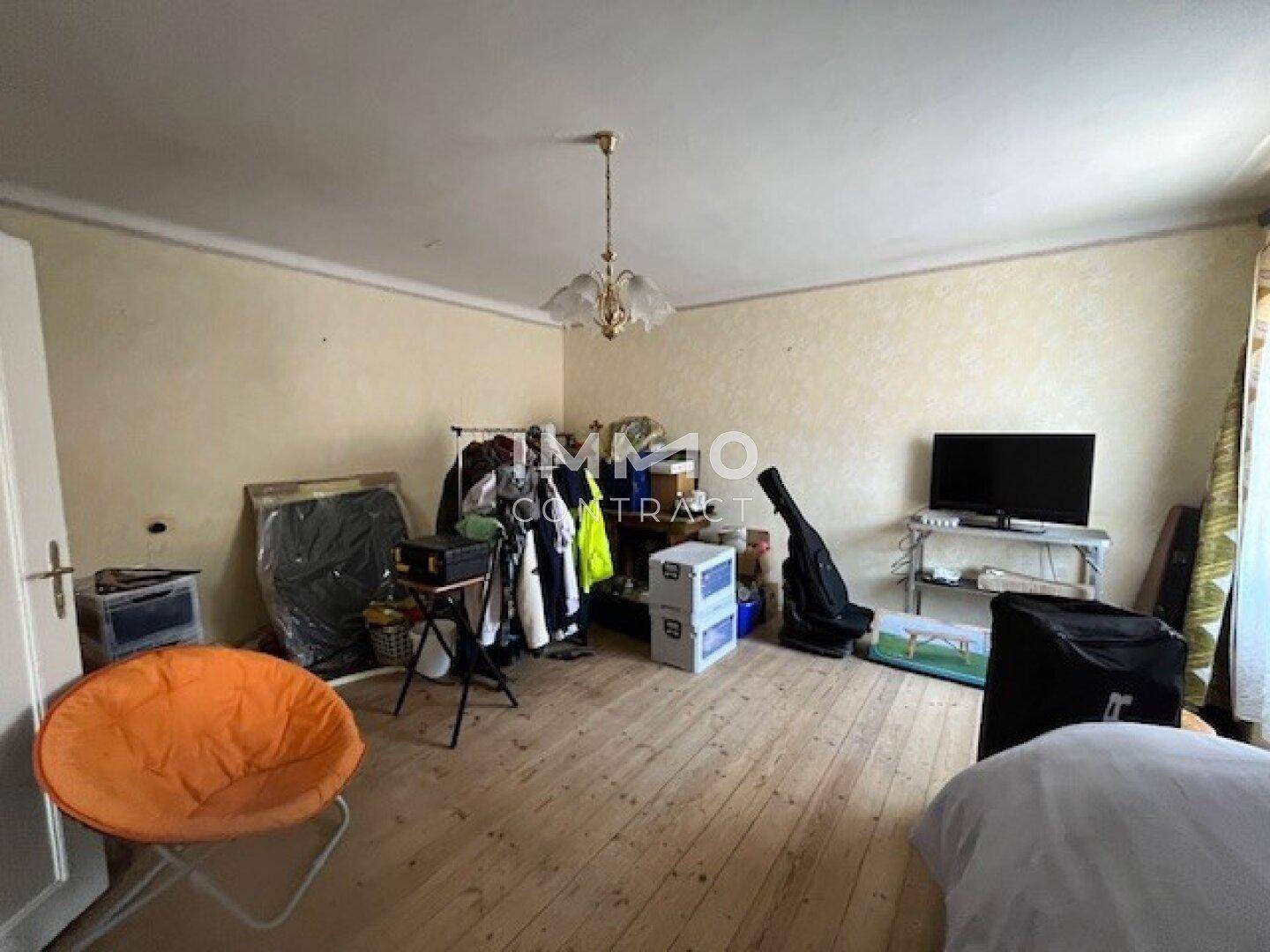 Unaufgeräumtes Zimmer mit Holzdielenboden und verschiedenen Gegenständen, als Abstellraum genutzt.