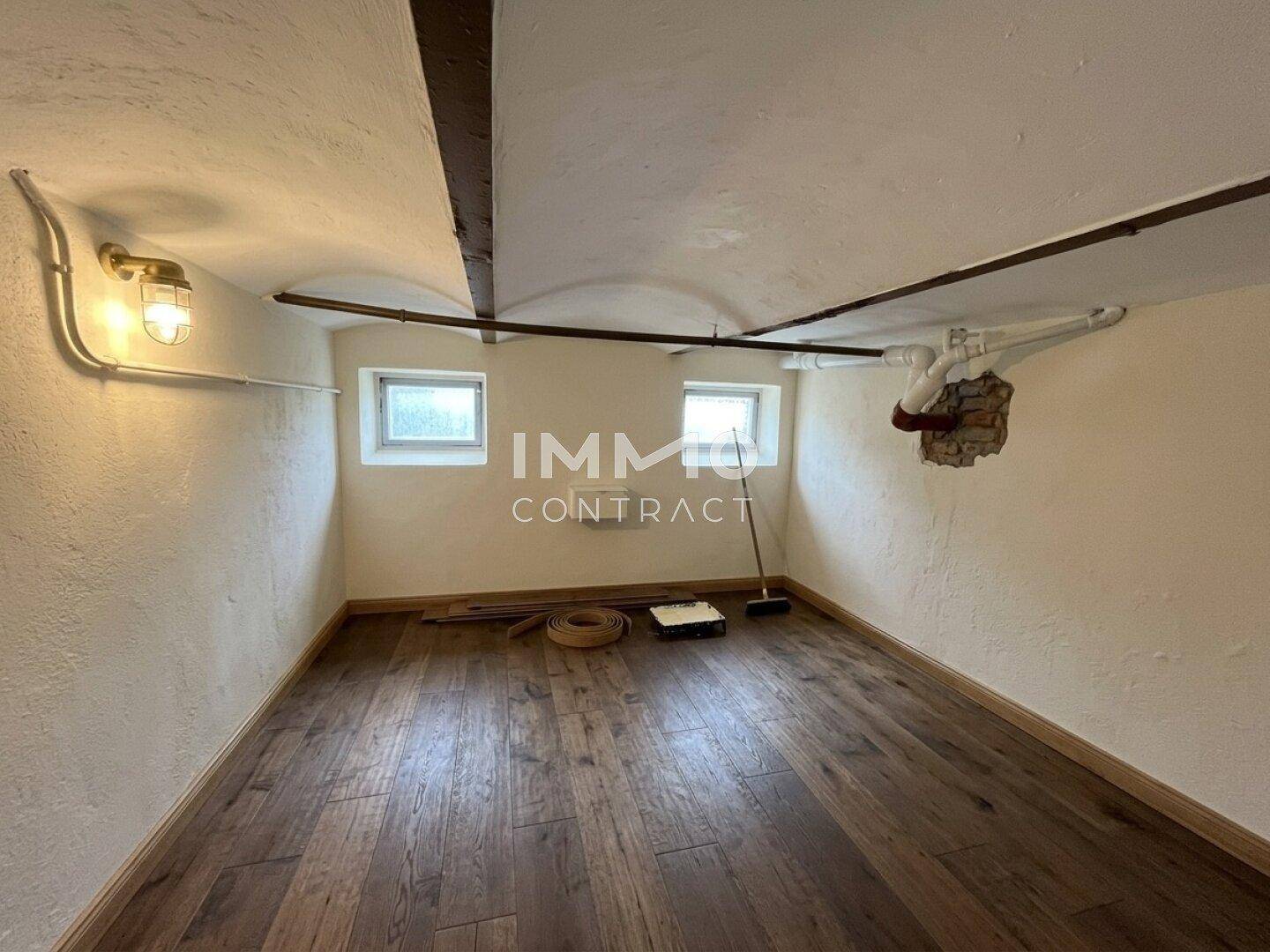 Renovierter Kellerraum mit Holzboden und kleinen Fenstern, hell und vielseitig nutzbar.