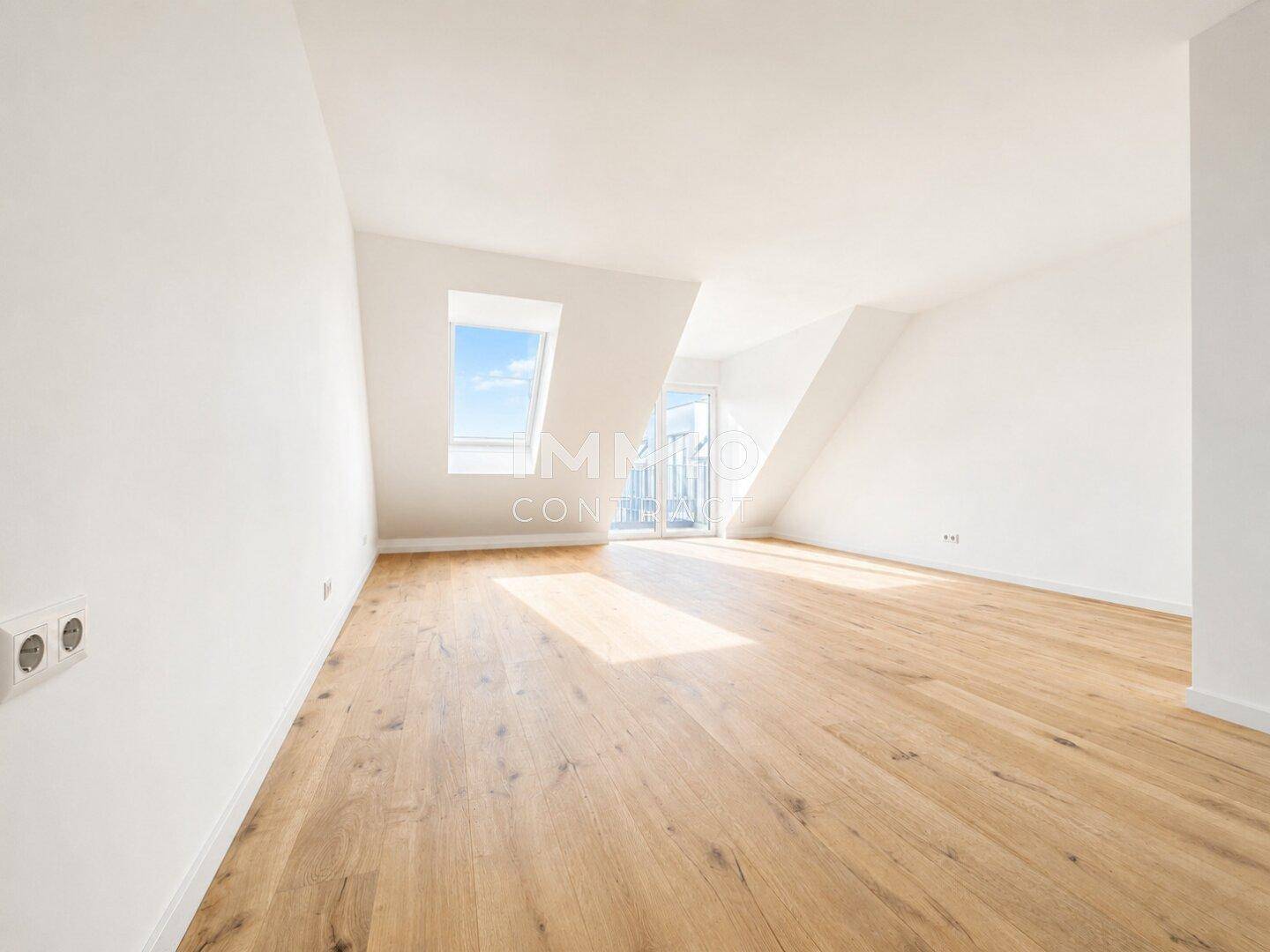 Lichtdurchfluteter Raum im Dachgeschoss mit Dachfenster und Zugang zu einem möglichen Balkon.