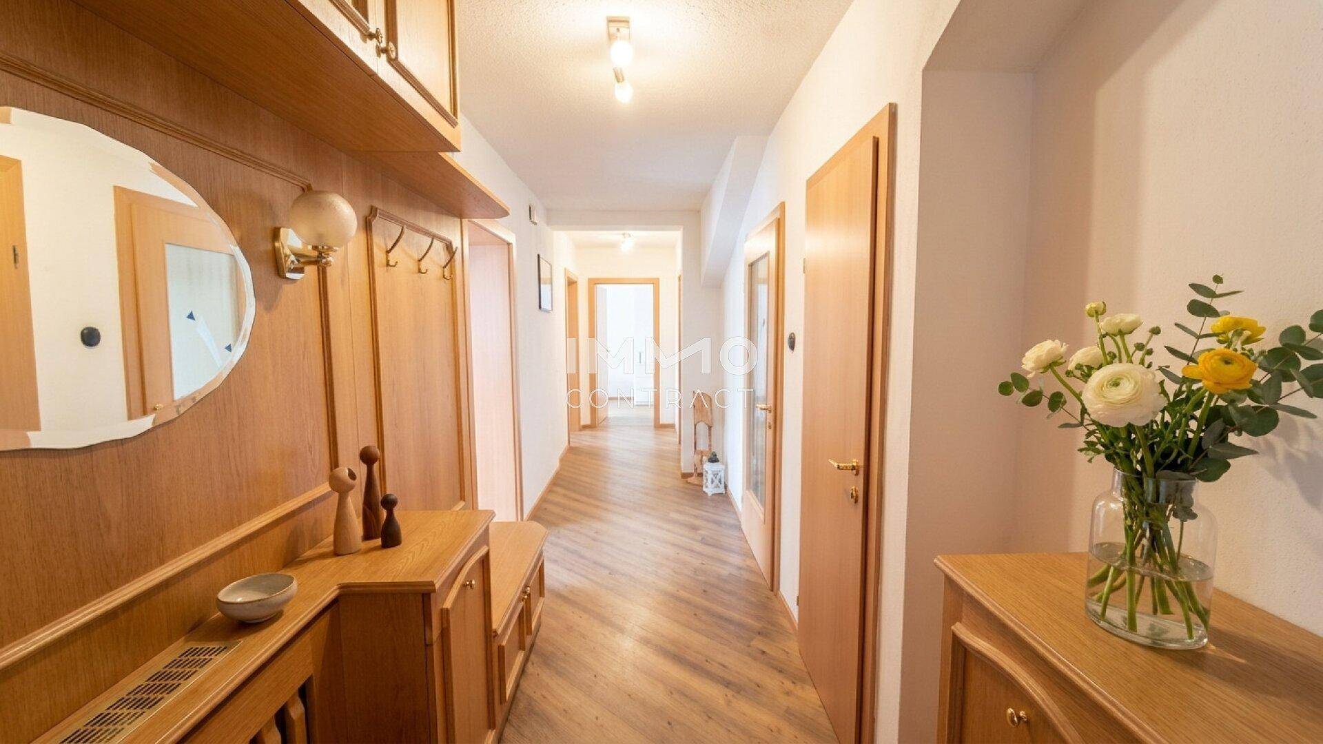 Heller Flur mit Holzvertäfelung, Garderobe und einer Kombination aus Fliesen- und Holzboden.
