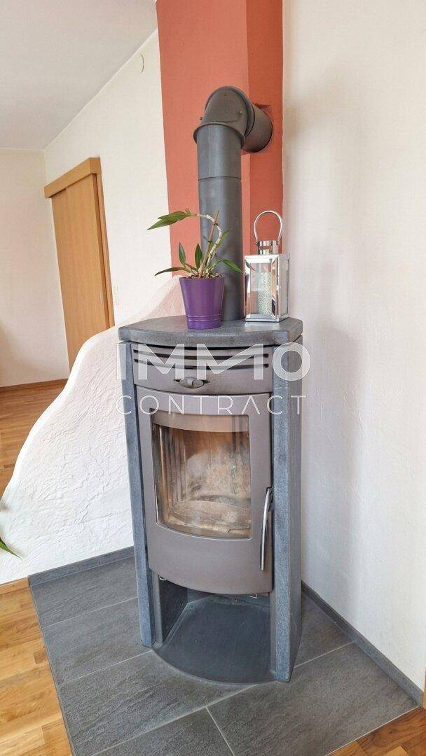 Moderner Kaminofen auf Fliesenboden, der eine gemütliche Atmosphäre im Wohnbereich schafft.