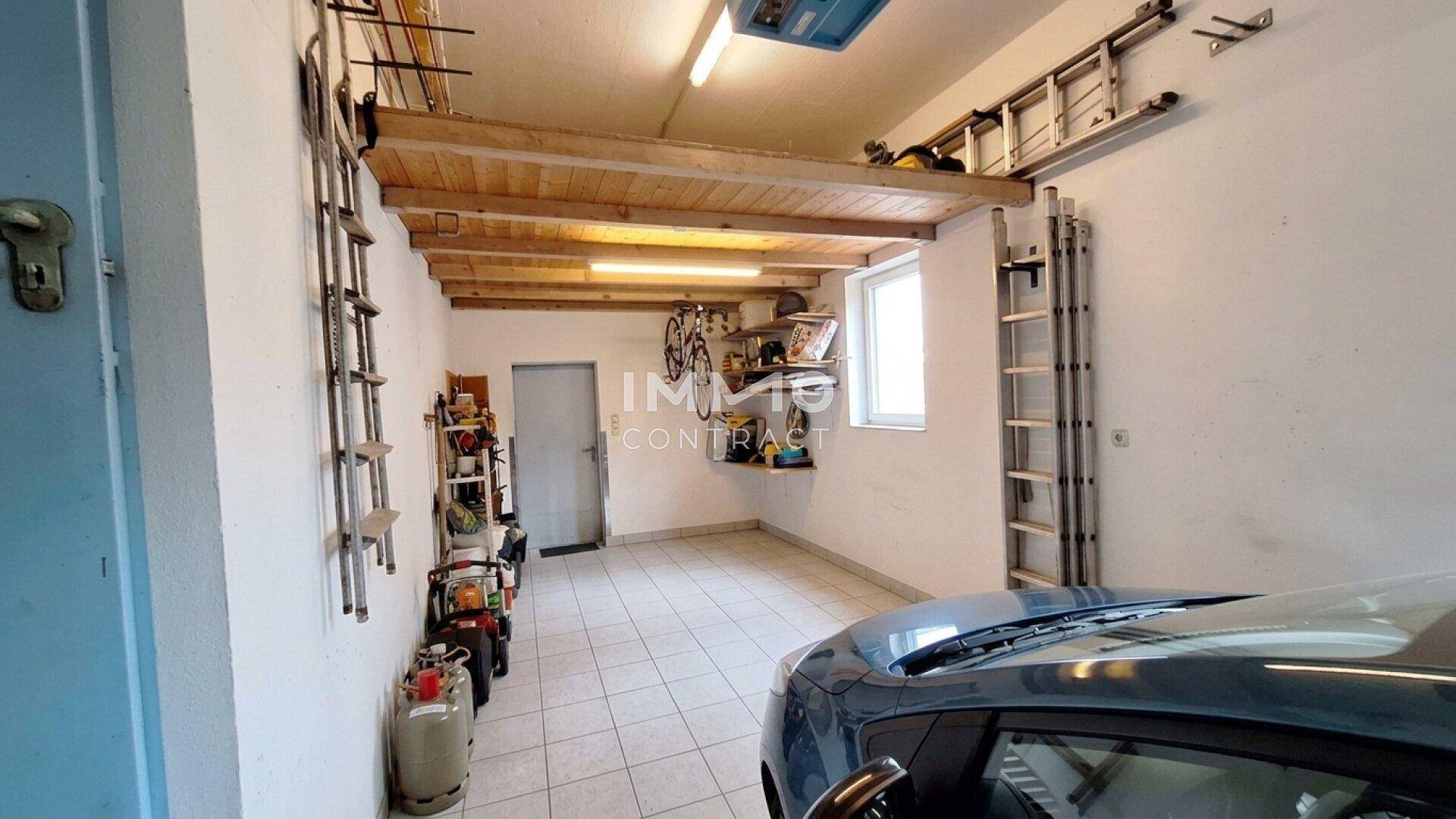 Geräumige Garage mit Stauraum, Werkzeugen und Fenster, bietet viel Platz.