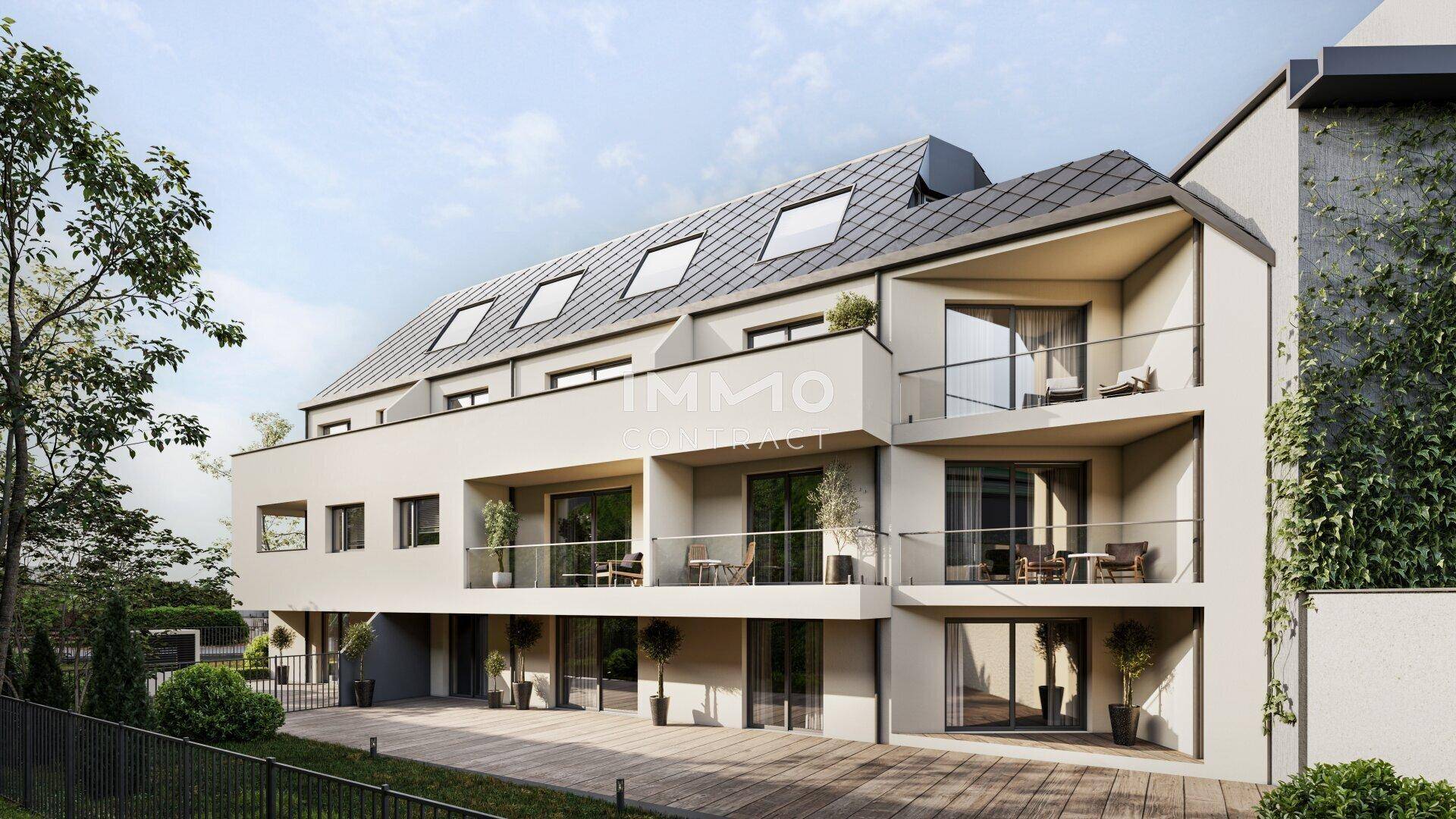 Moderne Wohnanlage mit mehreren Balkonen, Dachfenstern und heller Fassade.