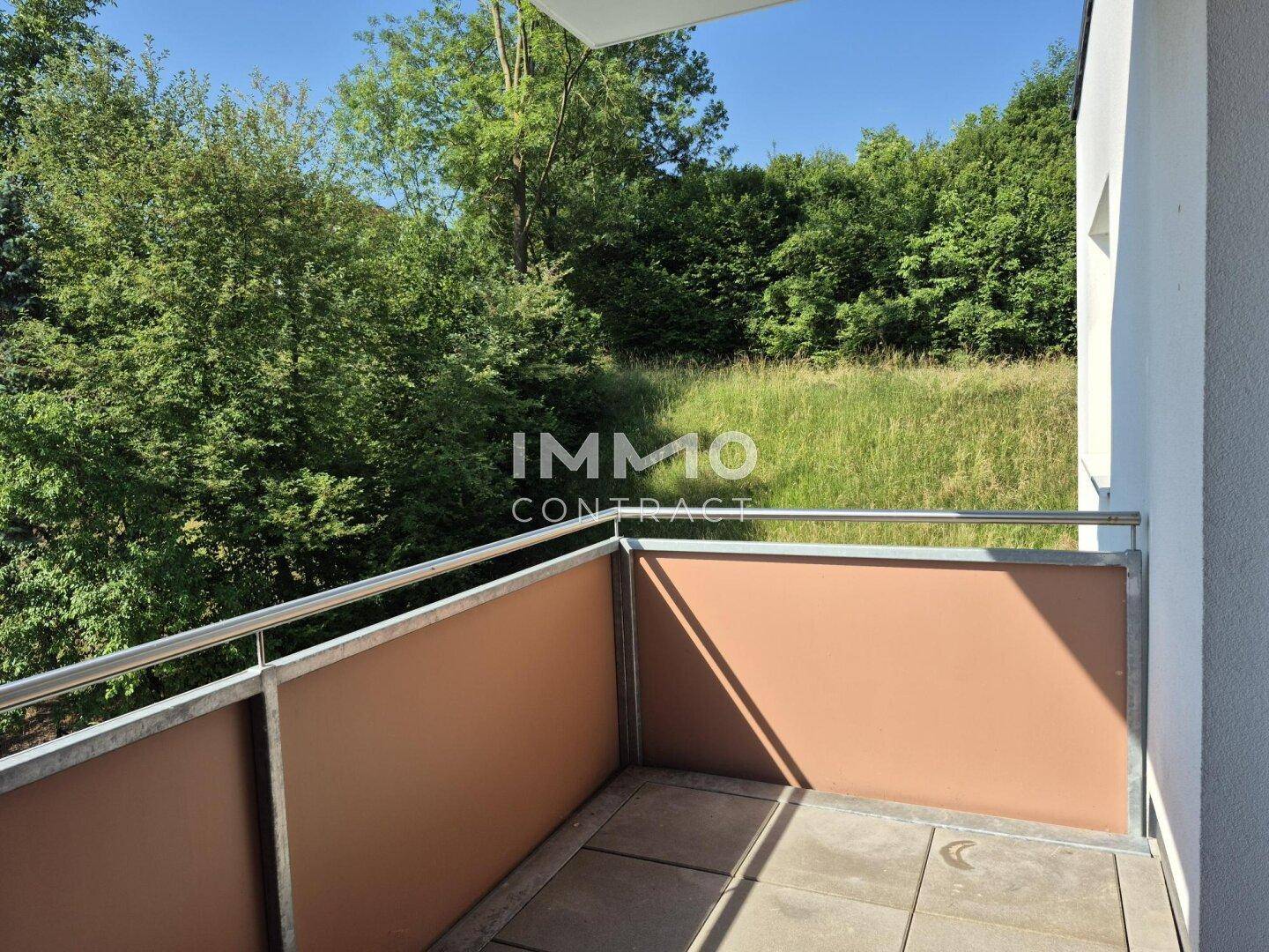 Balkon mit Metallgeländer und weitem Blick ins Grüne und auf die Natur.