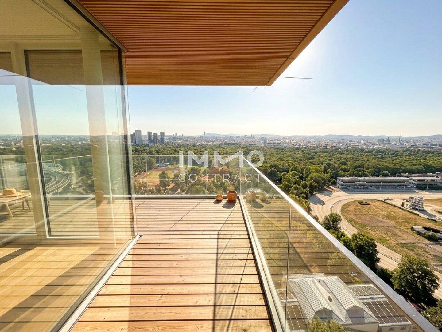 Weitläufige Terrasse mit Holzdielen und Panoramablick auf die Stadt und umliegende Natur.