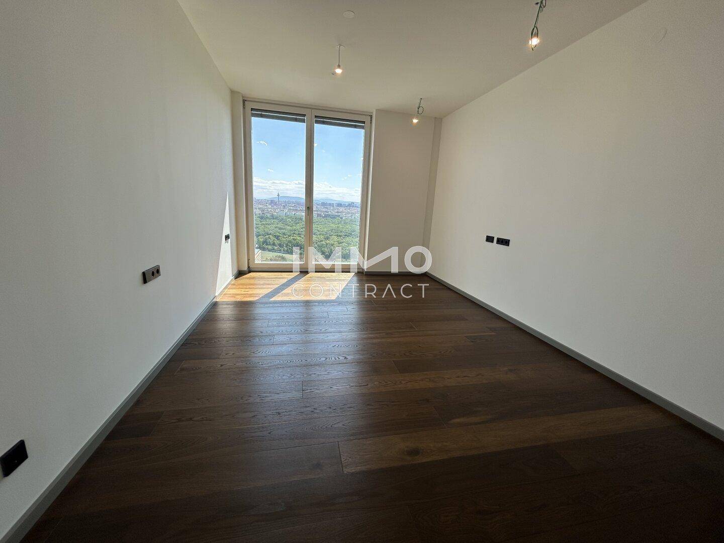 Helles Zimmer mit Holzboden und großen Fenstern bietet einen schönen Ausblick.