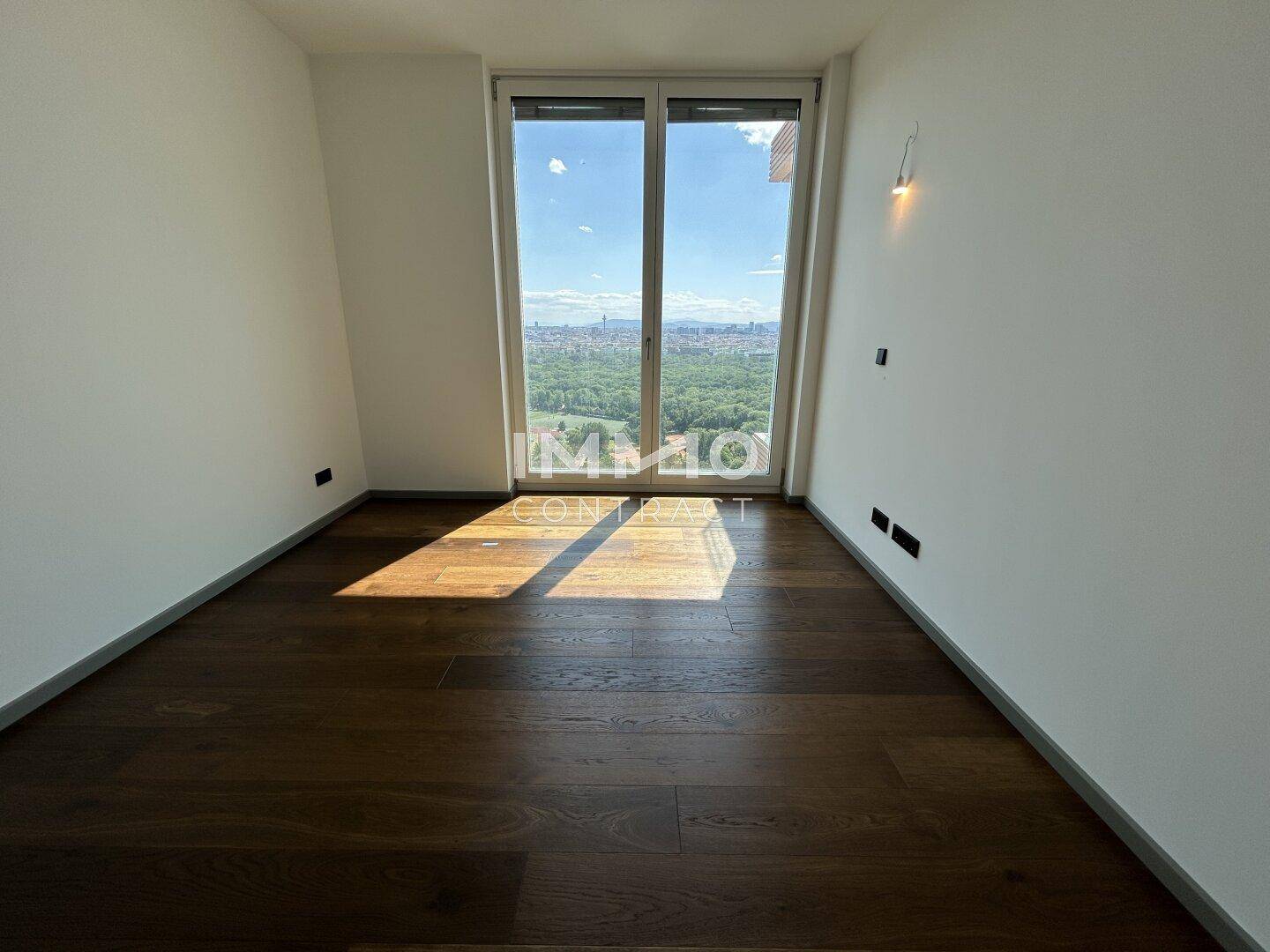 Geräumiges Zimmer mit Holzboden und großen Fenstern bietet einen weiten Blick.
