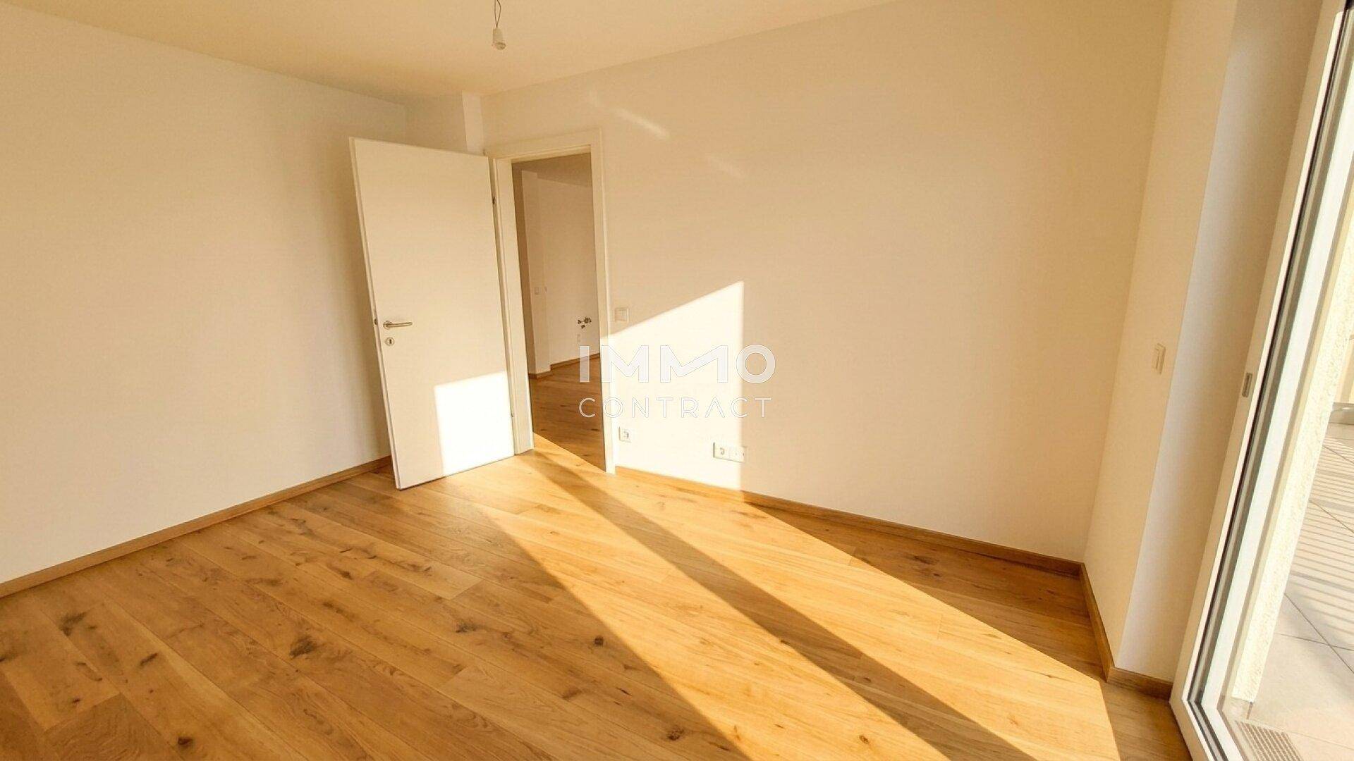 Sonniger Raum mit Holzboden und viel Tageslicht, ideal als Schlafzimmer nutzbar.