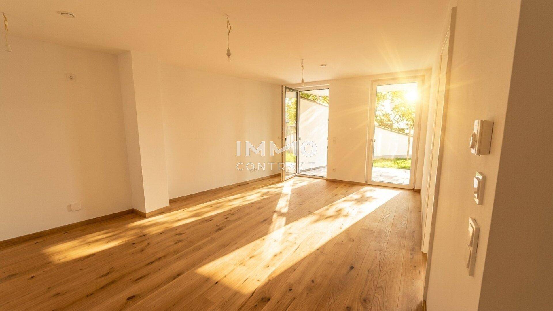 Lichtdurchfluteter Raum mit Holzboden und mehreren Zugängen zum Außenbereich, sehr hell.